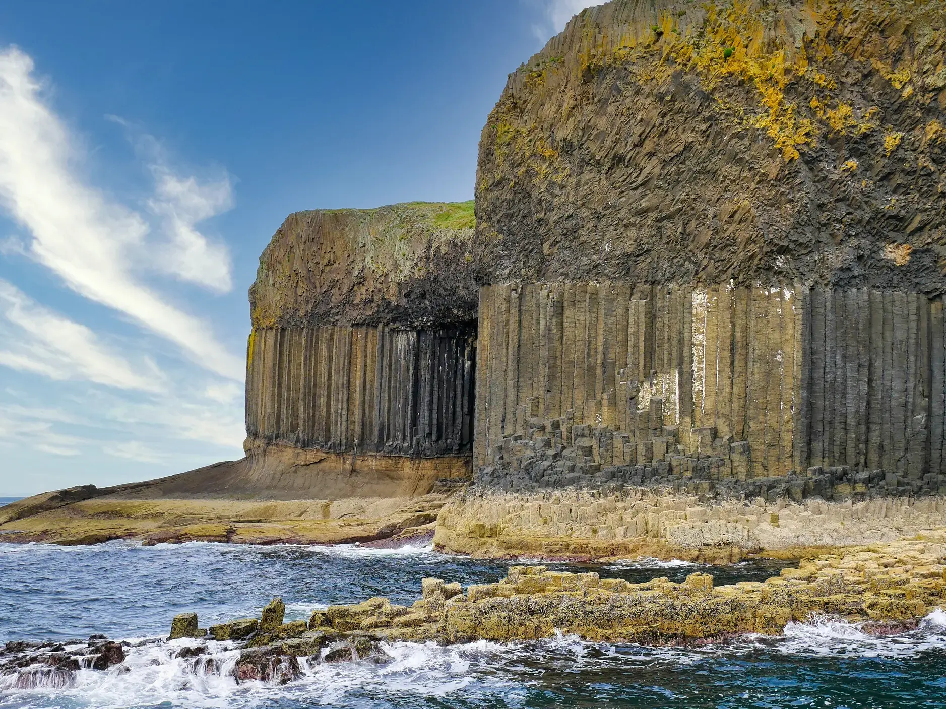 Beeindruckende Basaltsäulen an der Fingal's Cave auf der schottischen Vulkaninsel Staffa, umspült von den Wellen des Meeres.