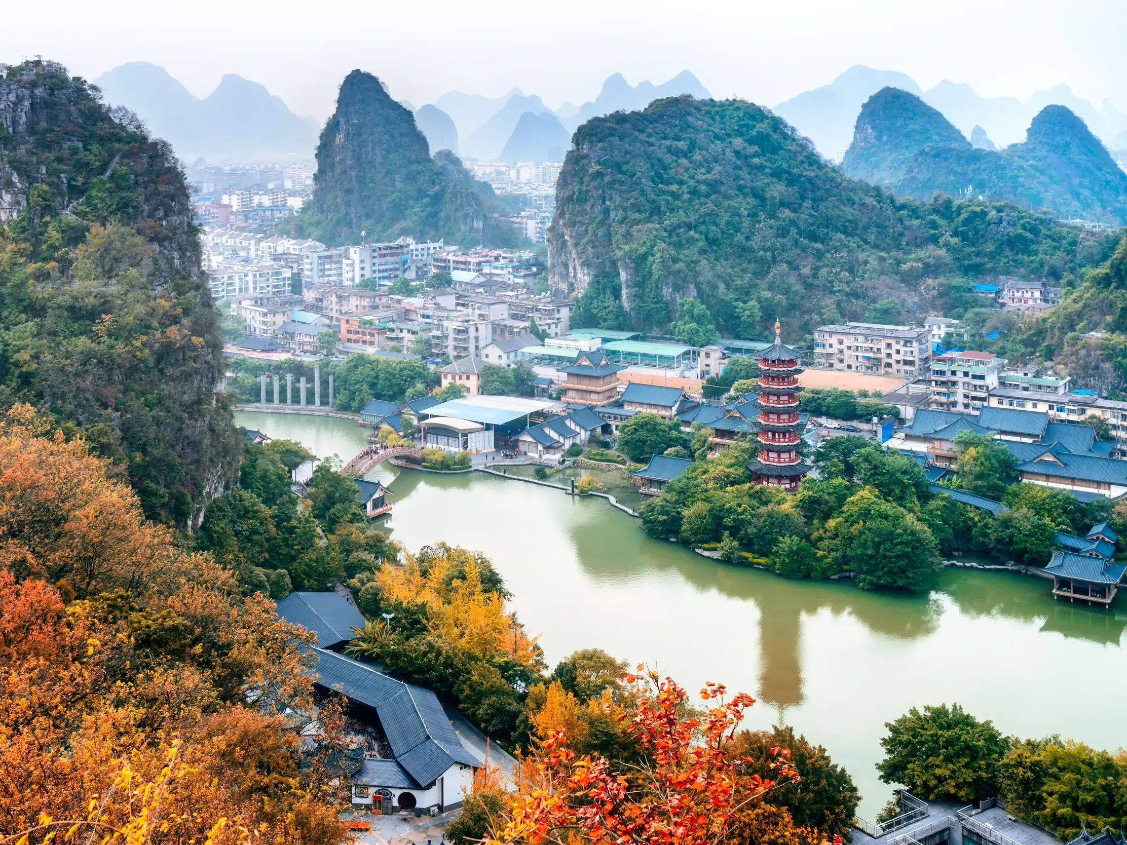 Erhöhte Ansicht der Stadt Guilin in China, eingebettet in die markante Karstlandschaft mit einer Pagode am See.