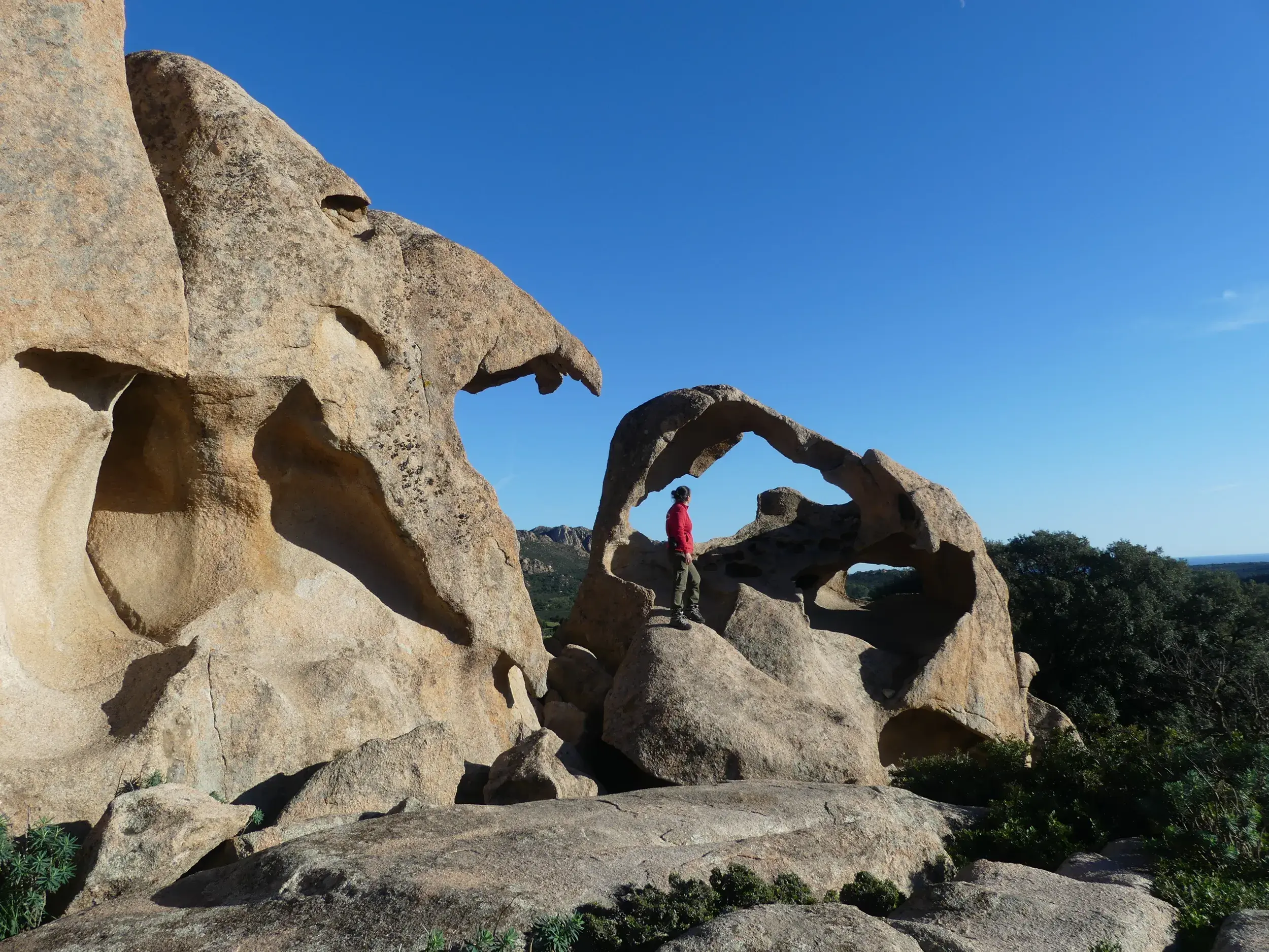Wanderer bestaunt die bizarren, von der Natur geformten Granitfelsen im Skulpturenpark bei Onifai auf Sardinien.