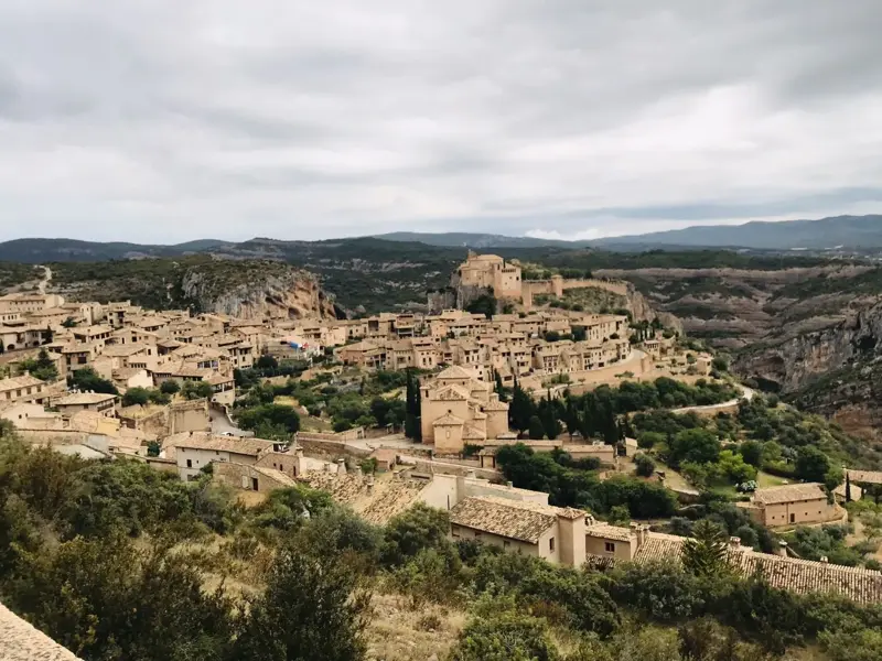 Weitblick auf das mittelalterliche Dorf Alquézar, eingebettet in die grüne Canyonlandschaft der Sierra de Guara in Aragonien.