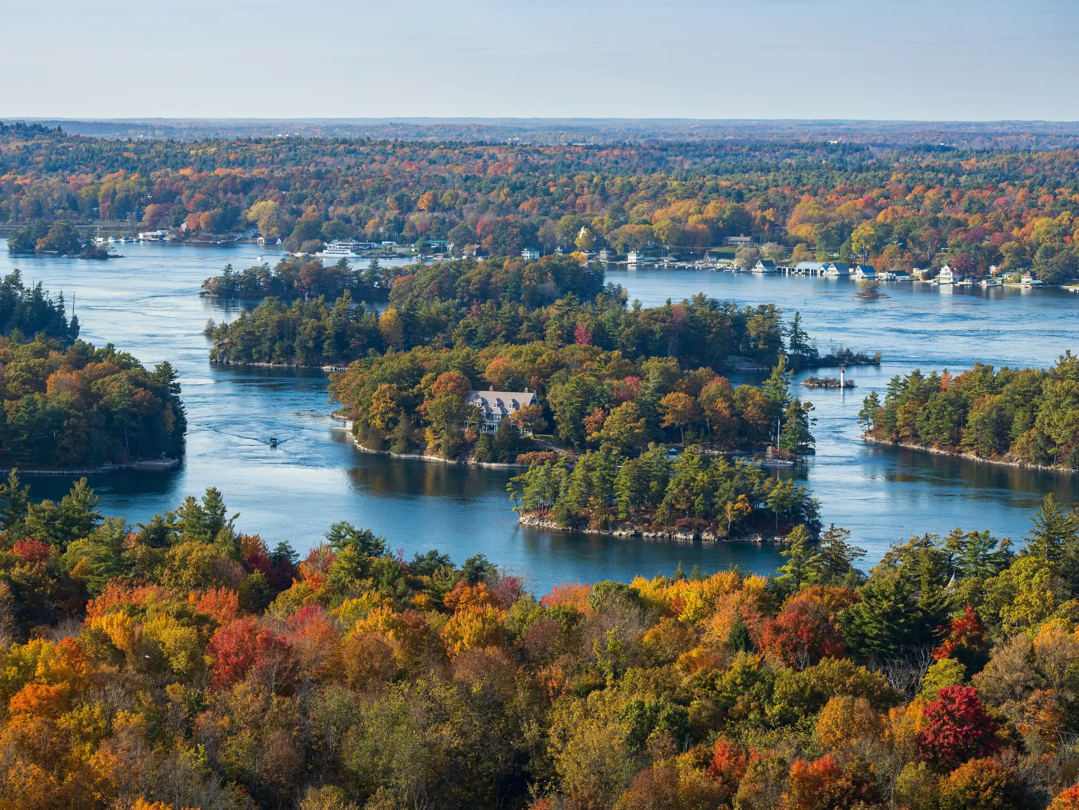 Erhöhter Ausblick auf die Thousand Islands im Sankt-Lorenz-Strom, dessen Ufer im bunten Herbstlaub des Indian Summer leuchten.