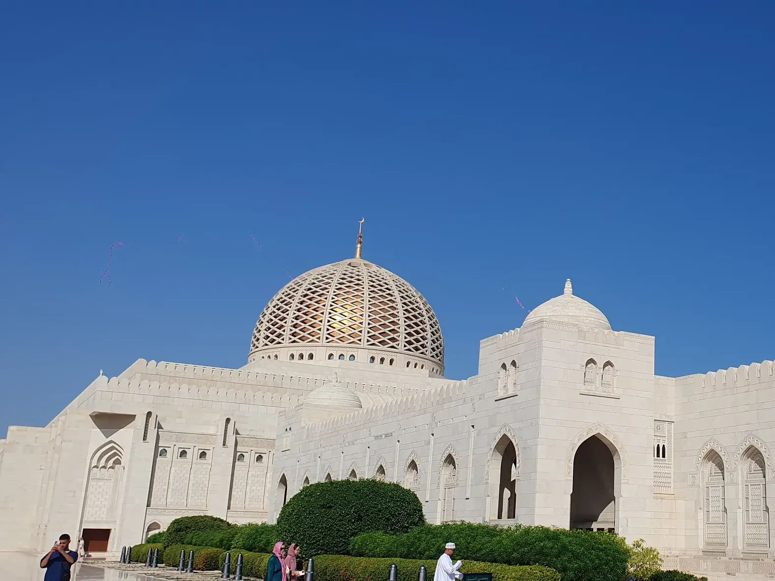 Die prächtige Sultan-Qabus-Moschee in Maskat mit ihrer goldenen Kuppel und weißen Fassade an einem sonnigen Tag im Oman.