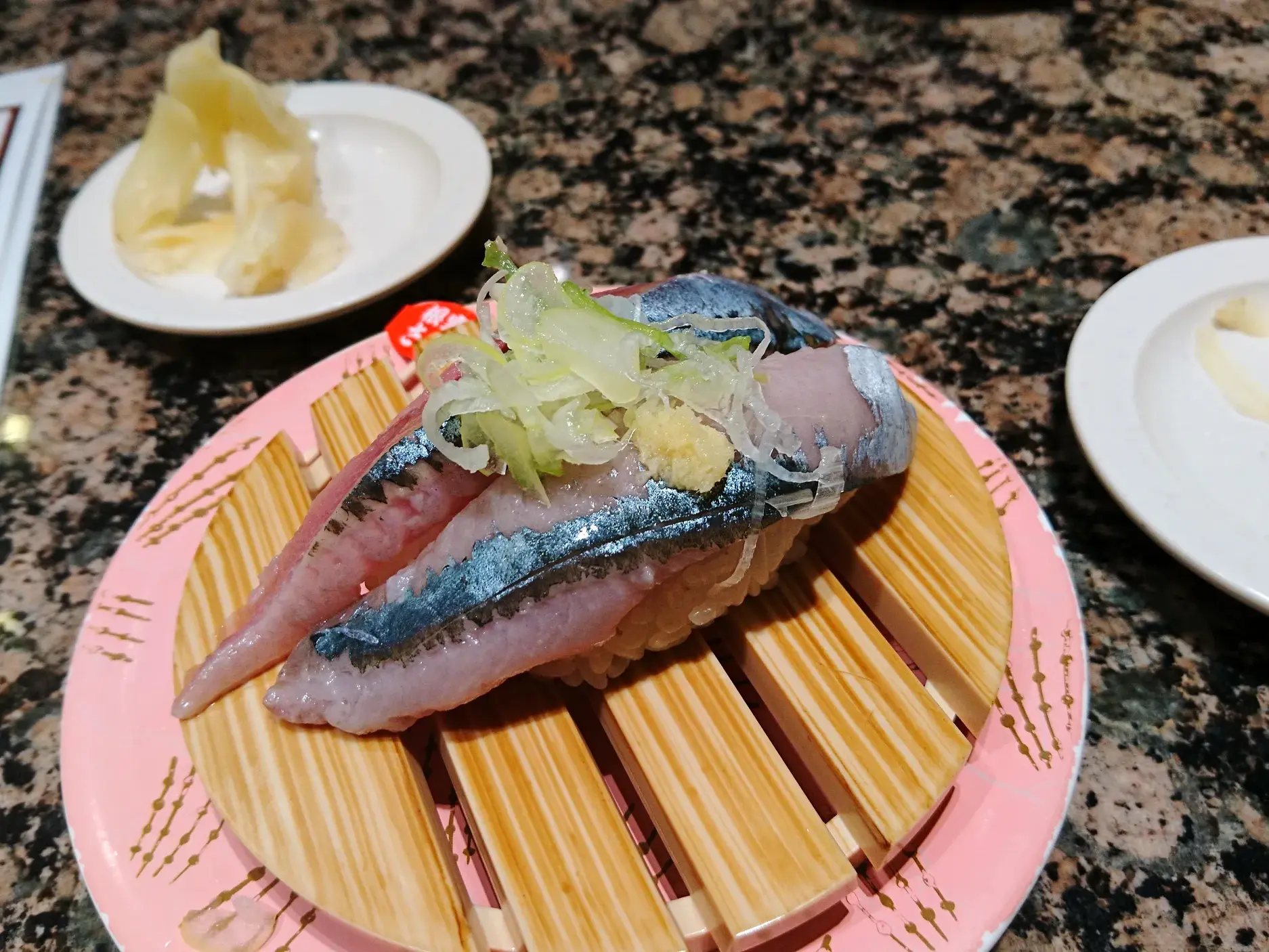 Authentisches Makrelen-Sushi, serviert auf einem Bambus-Untersatz in einem Restaurant in Japan, eine kulinarische Entdeckung.