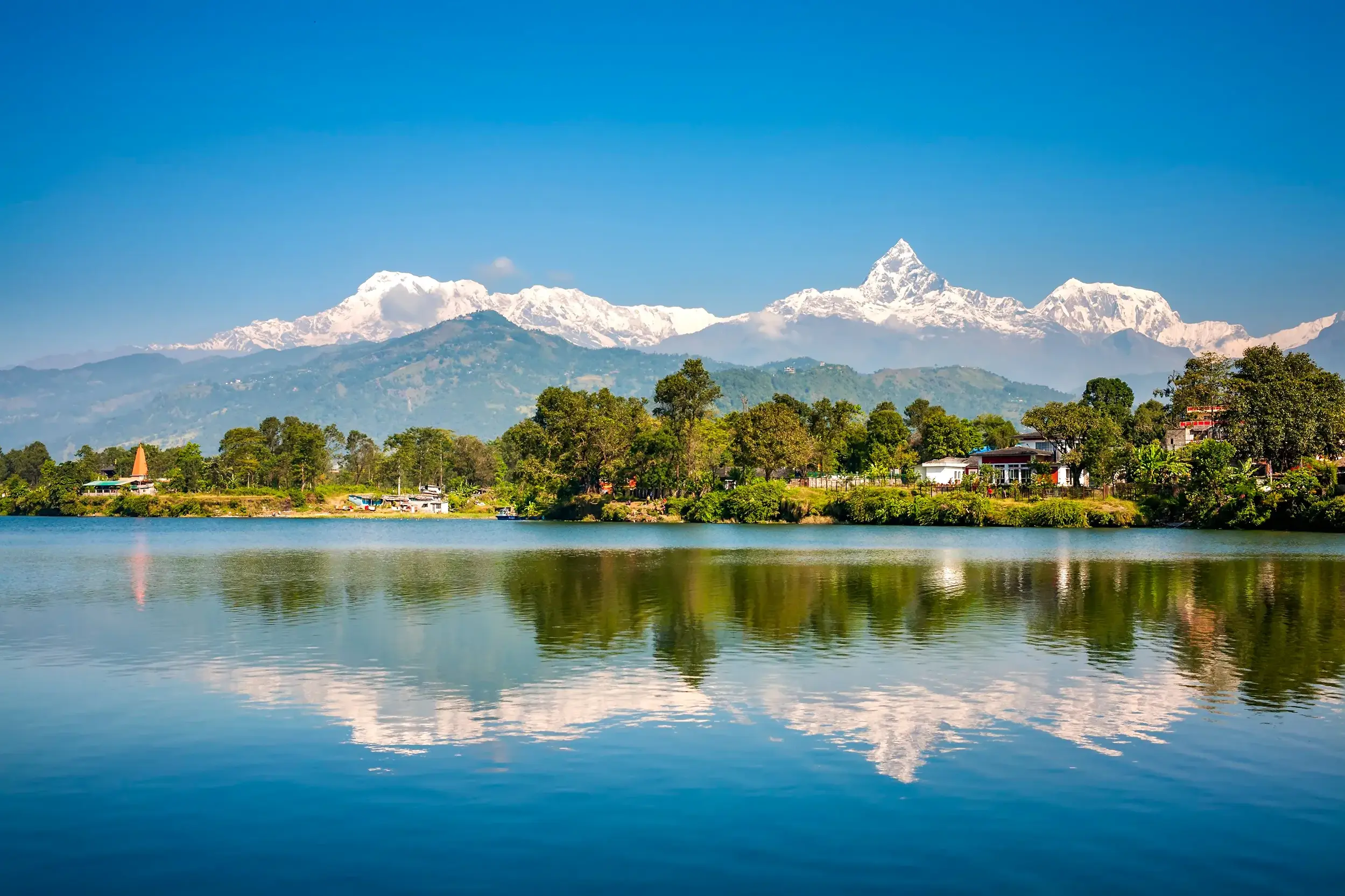 Malerische Spiegelung des Annapurna-Massivs und des markanten Machapuchare im ruhigen Phewa-See bei Pokhara, Nepal.
