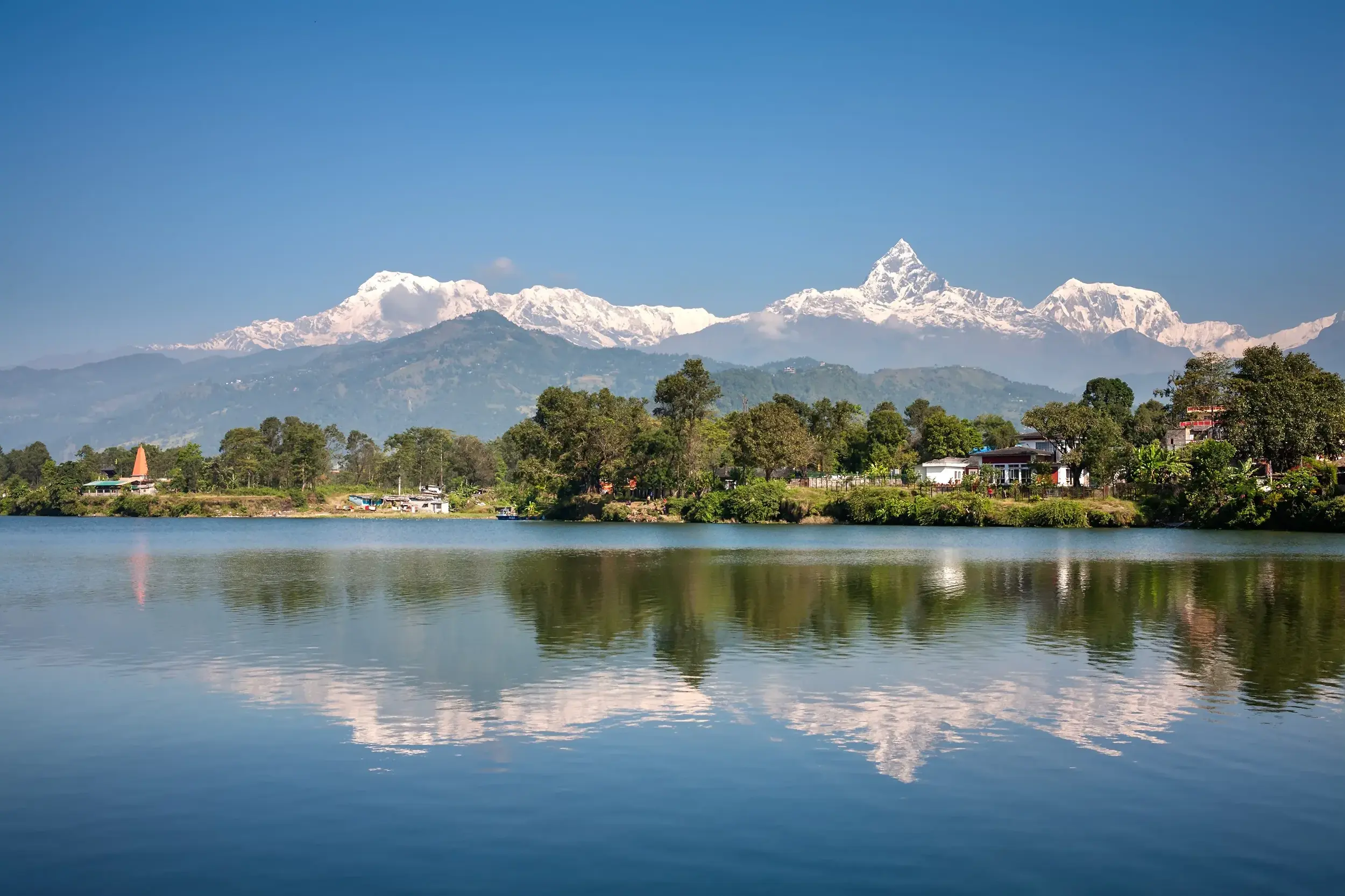 Malerische Spiegelung des Annapurna-Massivs und des markanten Machapuchare im ruhigen Phewa-See bei Pokhara, Nepal.