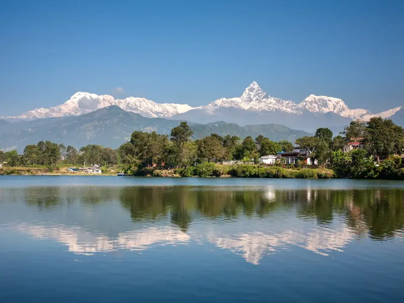 Malerische Spiegelung des Annapurna-Massivs und des markanten Machapuchare im ruhigen Phewa-See bei Pokhara, Nepal.