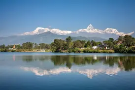 Malerische Spiegelung des Annapurna-Massivs und des markanten Machapuchare im ruhigen Phewa-See bei Pokhara, Nepal.