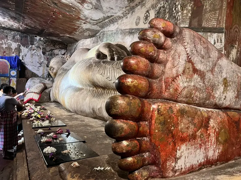 Nahaufnahme der bemalten Füße der riesigen, liegenden Buddha-Statue im historischen Höhlentempel von Dambulla, Sri Lanka.