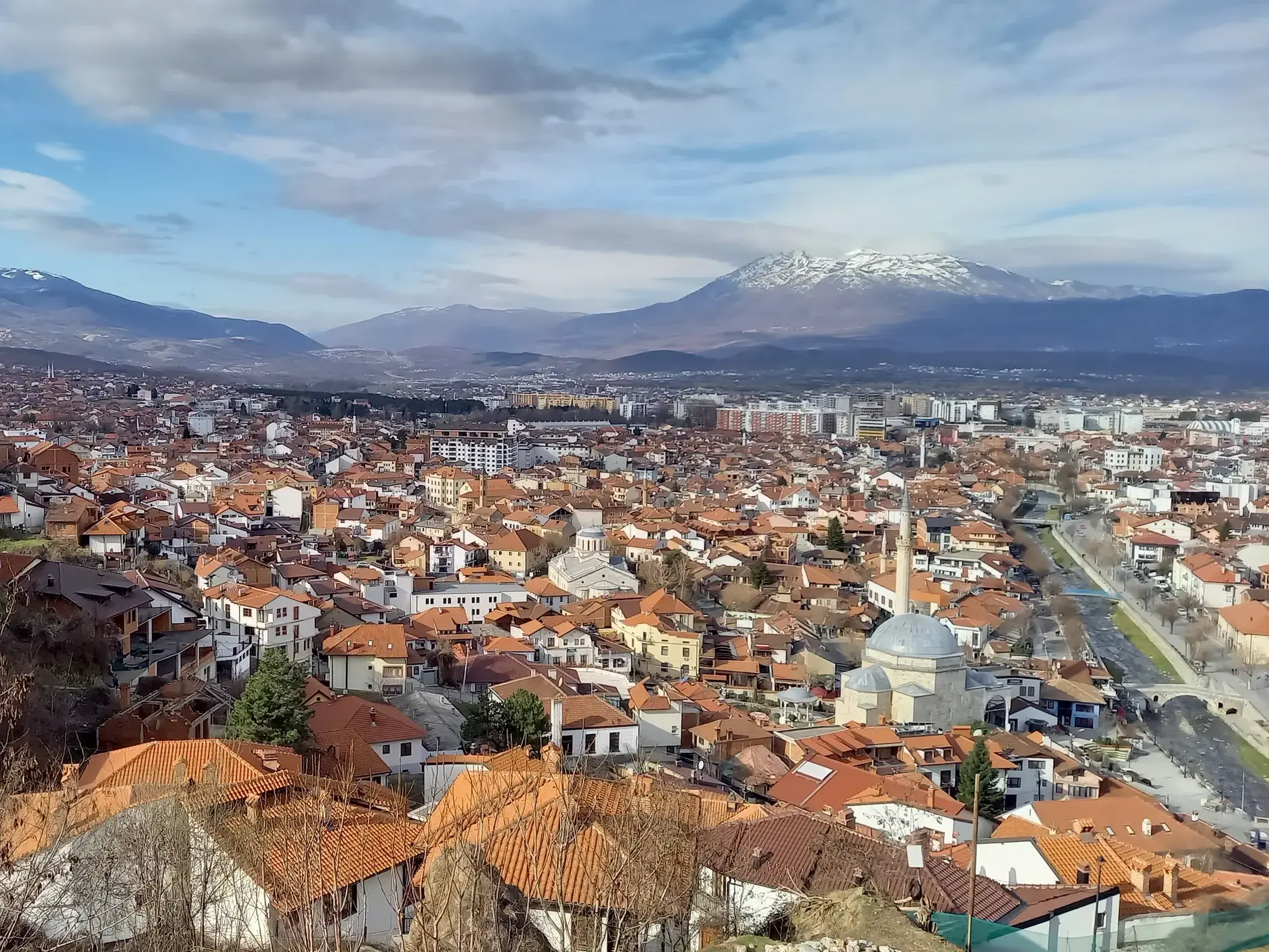 Panoramablick auf die Altstadt von Prizren im Kosovo mit Moschee und den schneebedeckten Gipfeln des Sharr-Gebirges.