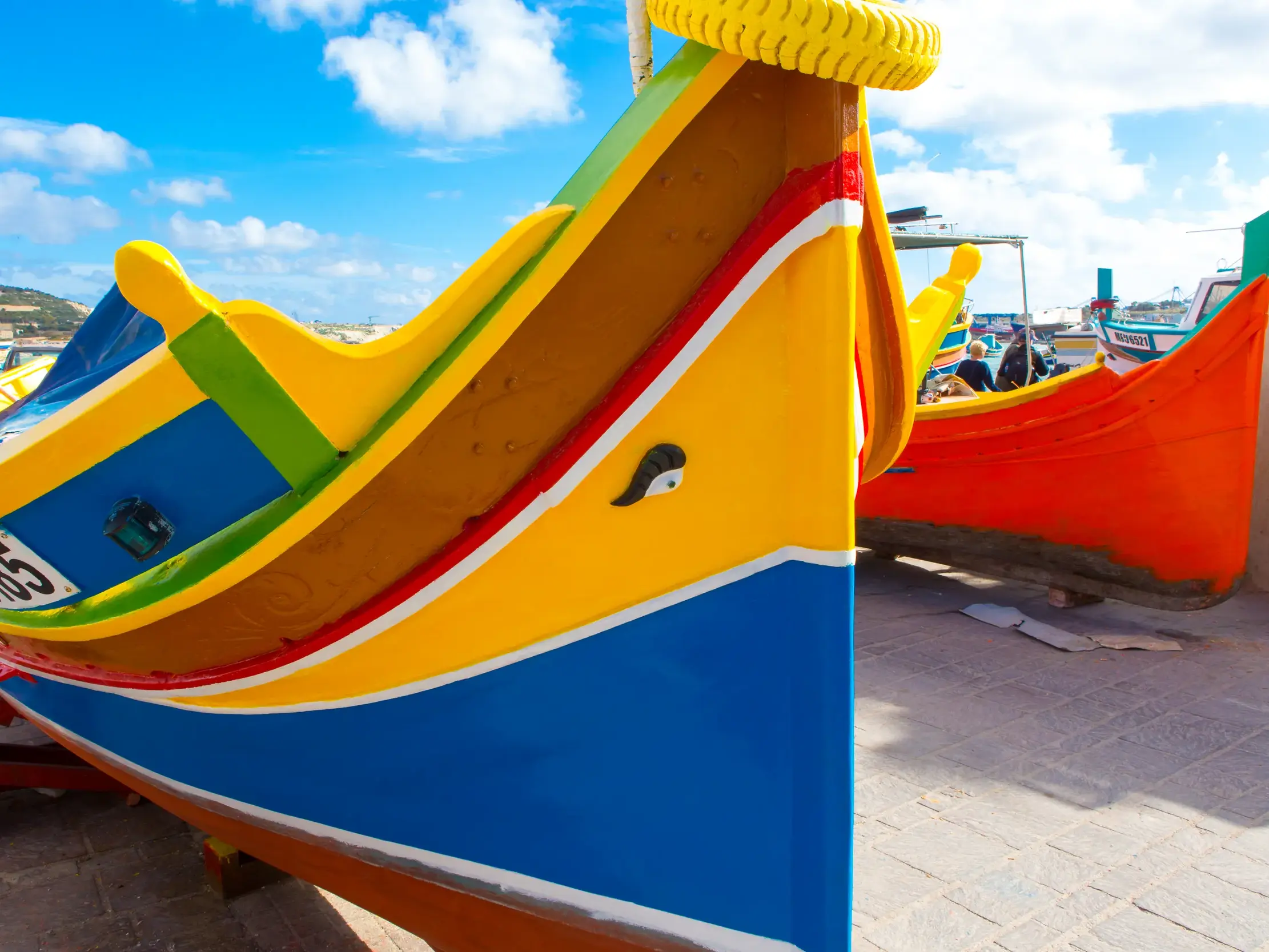 Nahaufnahme eines traditionellen, bunten Fischerboots mit dem Auge des Osiris, das im Hafen von Marsaxlokk an Land liegt.