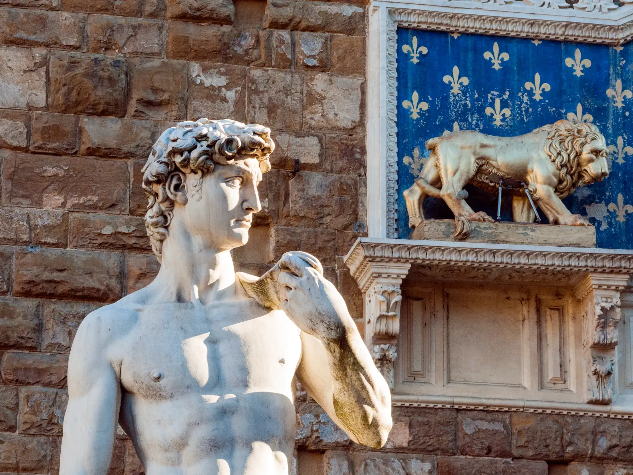 Detailansicht der David-Statue vor dem Palazzo Vecchio in Florenz, rechts der heraldische Marzocco-Löwe.