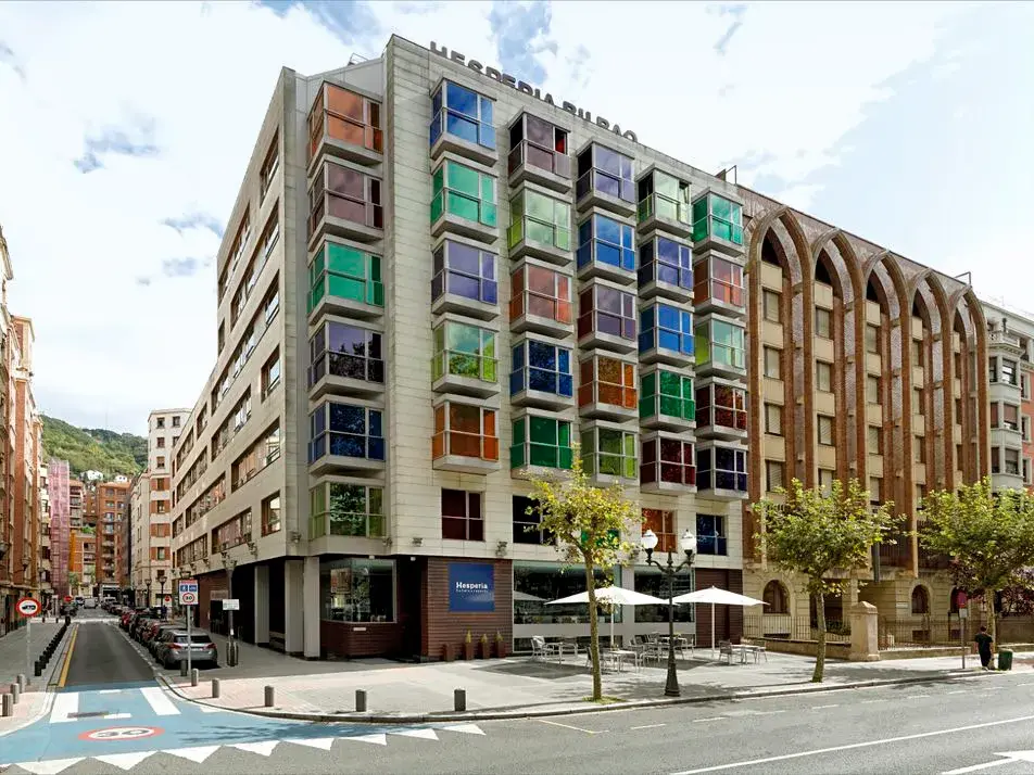 Außenansicht des zentral gelegenen Hotel Hesperia Bilbao mit seiner markanten Architektur mit vielen bunten Fenstern.