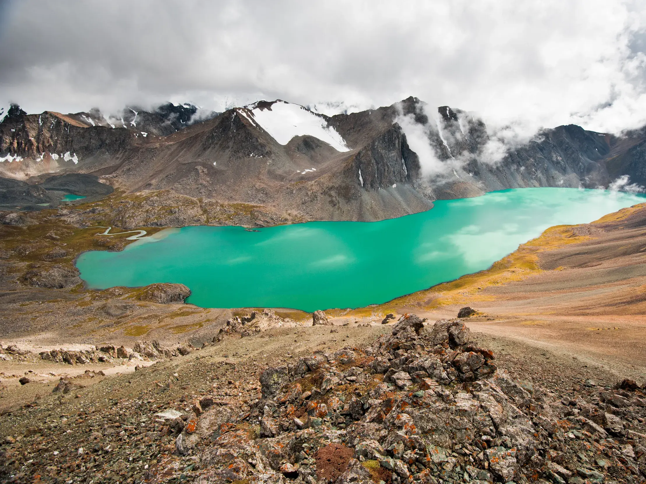 Panoramablick vom Trekkingpfad auf den türkisen Alaköl See im Terskej-Alatau-Gebirge in Kirgistan.