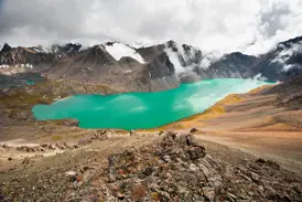 Panoramablick vom Trekkingpfad auf den türkisen Alaköl See im Terskej-Alatau-Gebirge in Kirgistan.