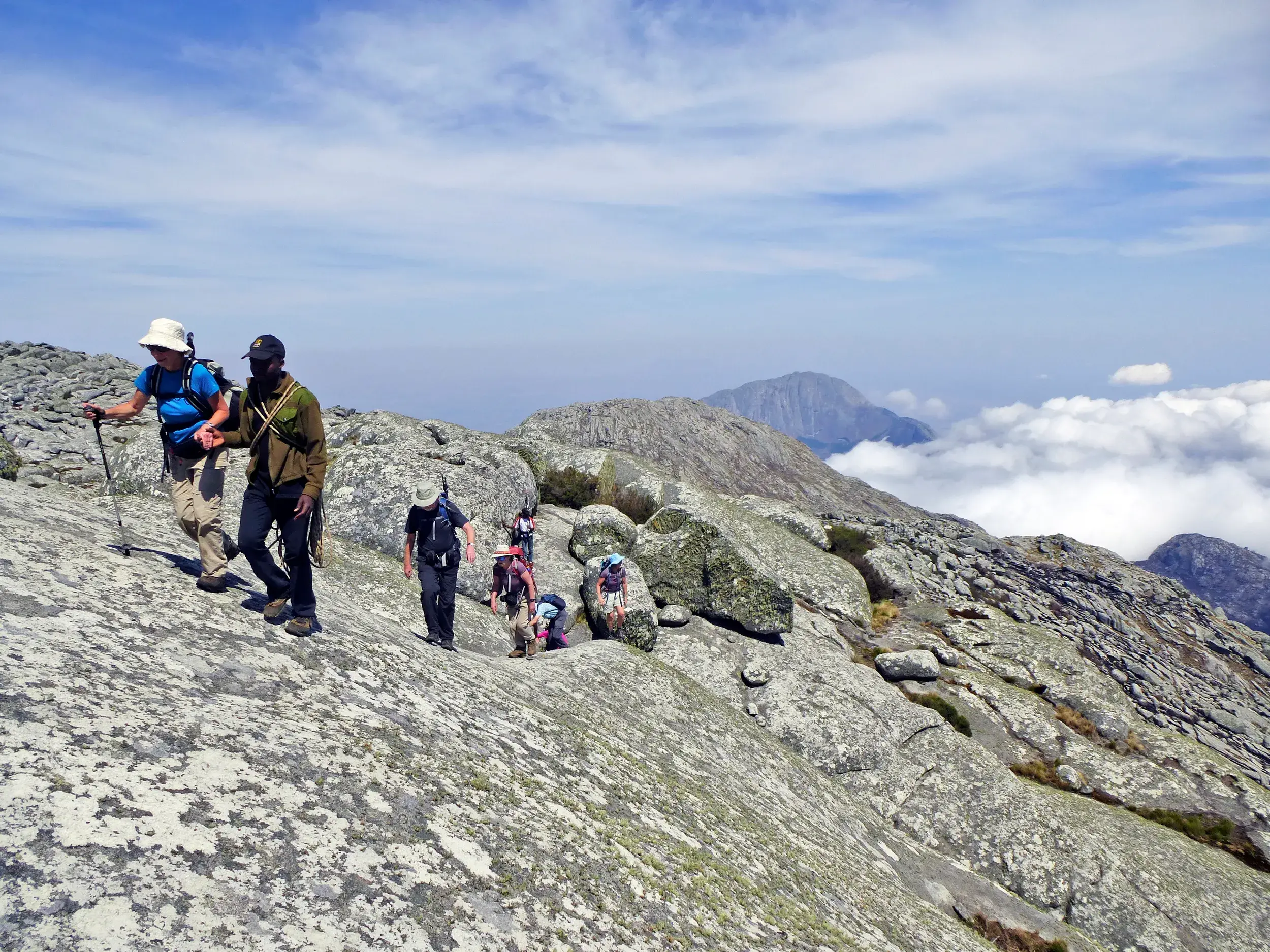 Ein lokaler Hauser-Reiseleiter führt eine Gruppe beim anspruchsvollen Trekking über Granitfelsen im Mulanje Massiv, Malawi.