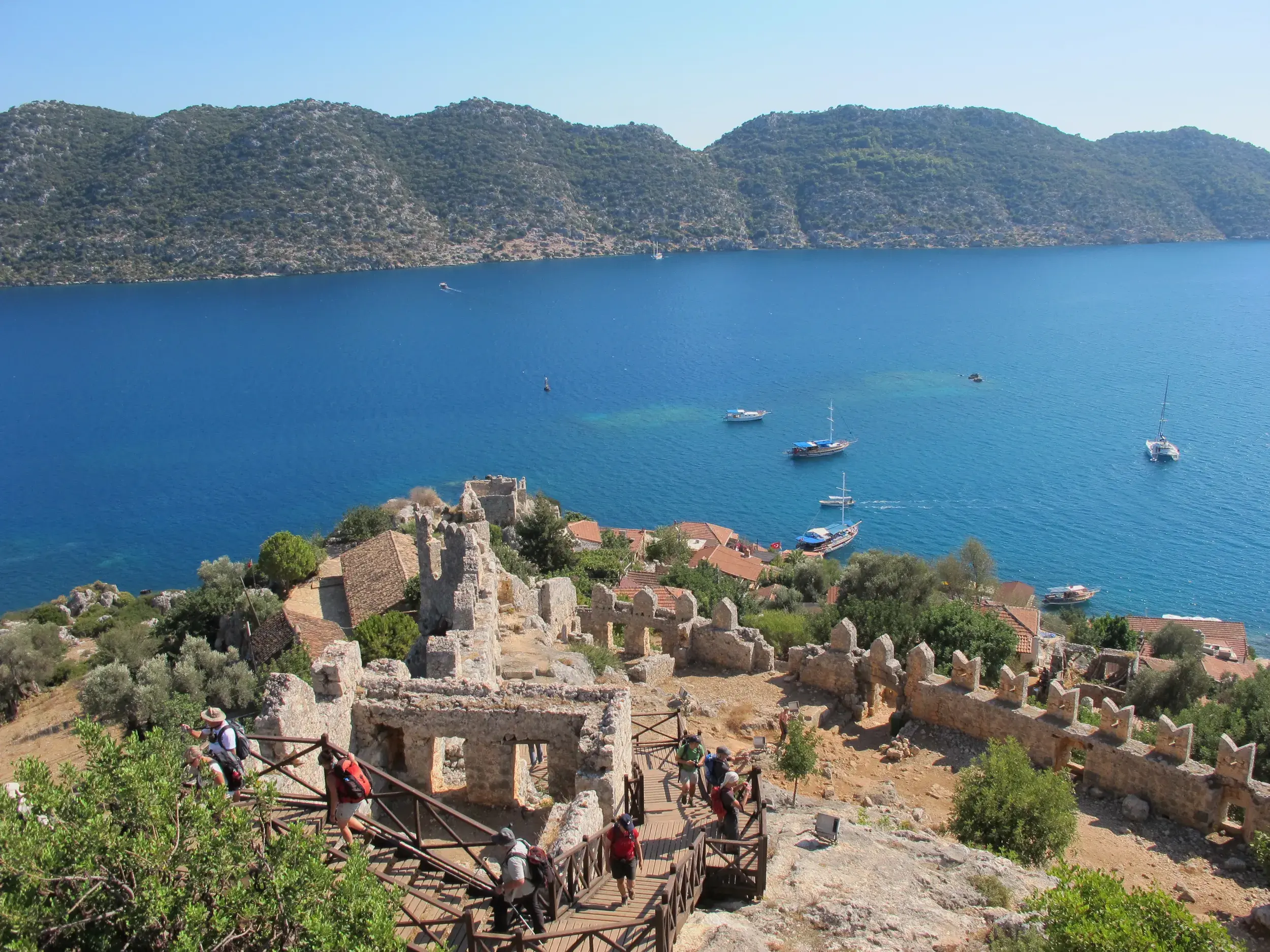 Wandergruppe erkundet die Burg von Simena auf dem Lykischen Weg mit Panoramablick über die tiefblaue Bucht von Kekova.