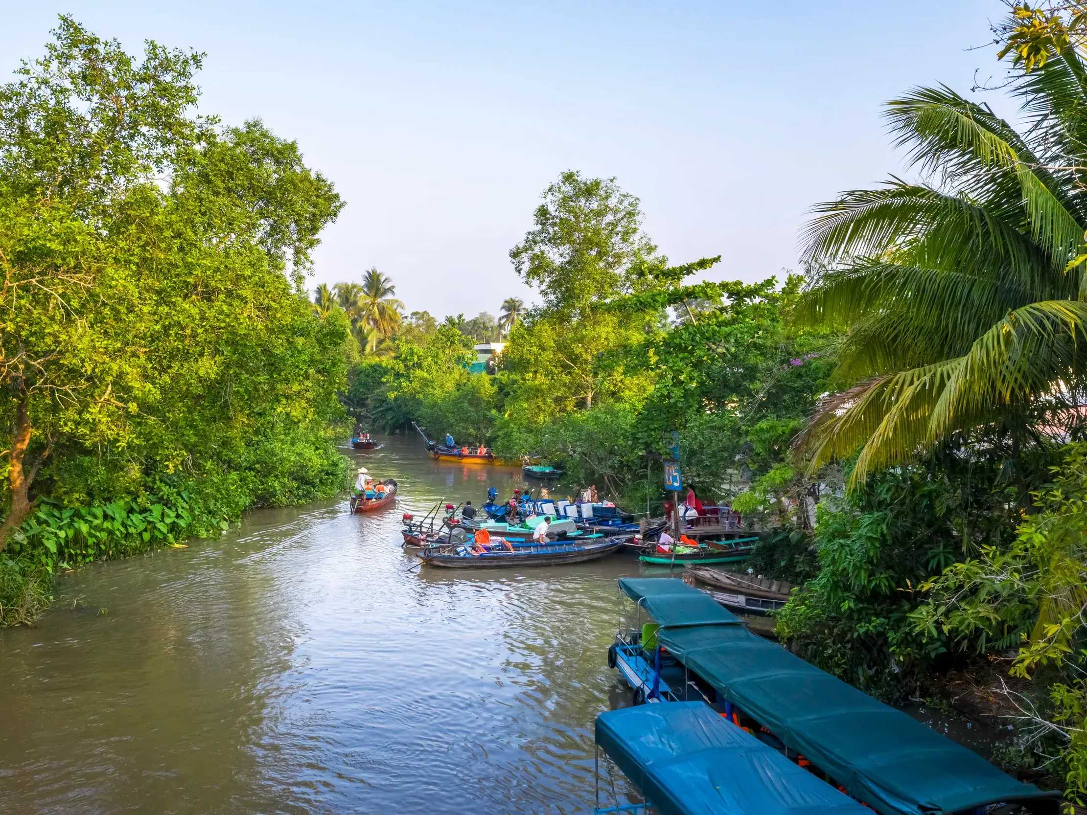Eine Reisegruppe erkundet mit kleinen Ausflugsbooten die üppig grünen Wasserwege des Mekongdeltas bei Cai Be in Vietnam.