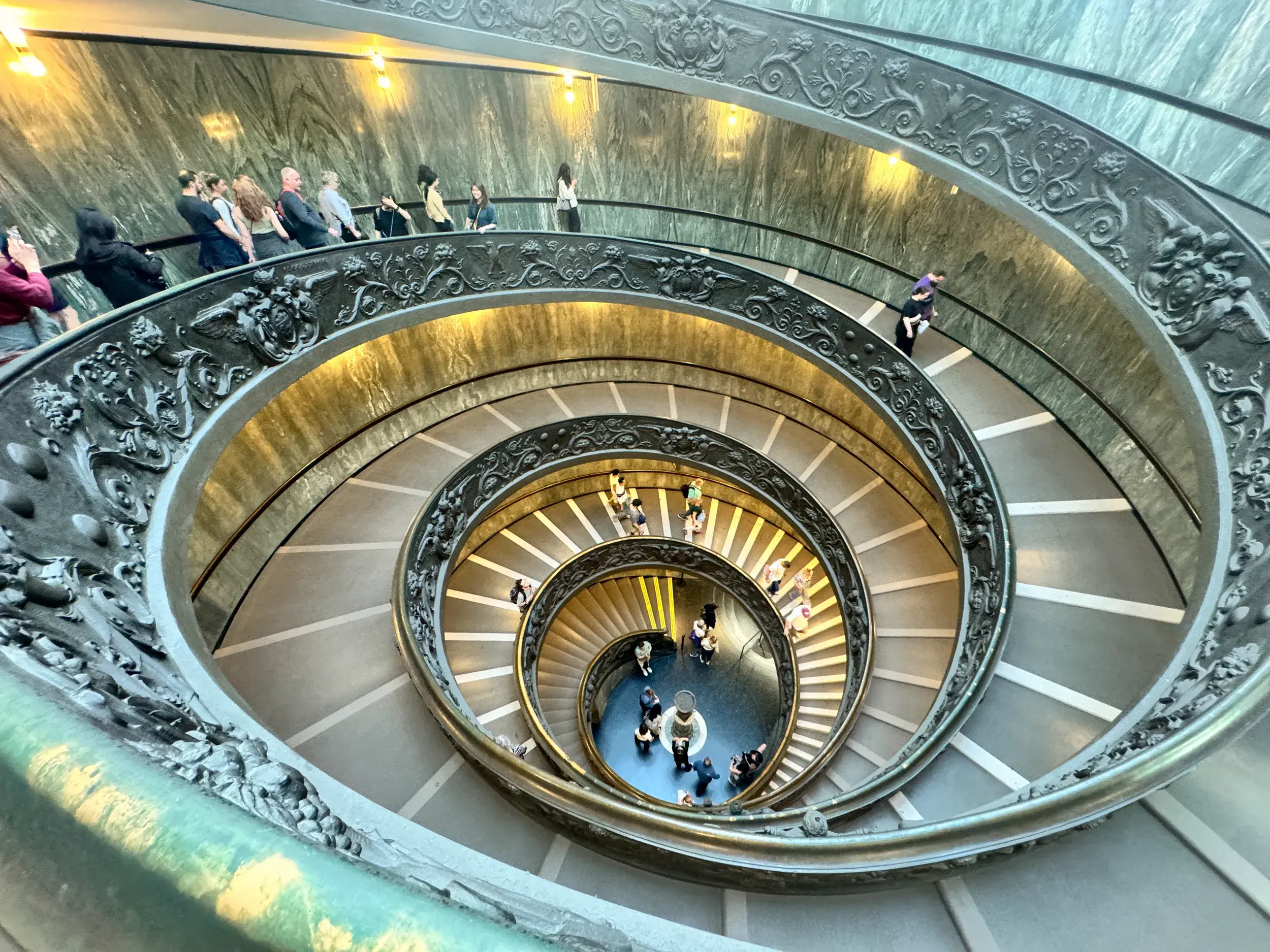 Blick von oben auf die gewundene Spiraltreppe mit Besuchern in den Vatikanischen Museen in Rom.