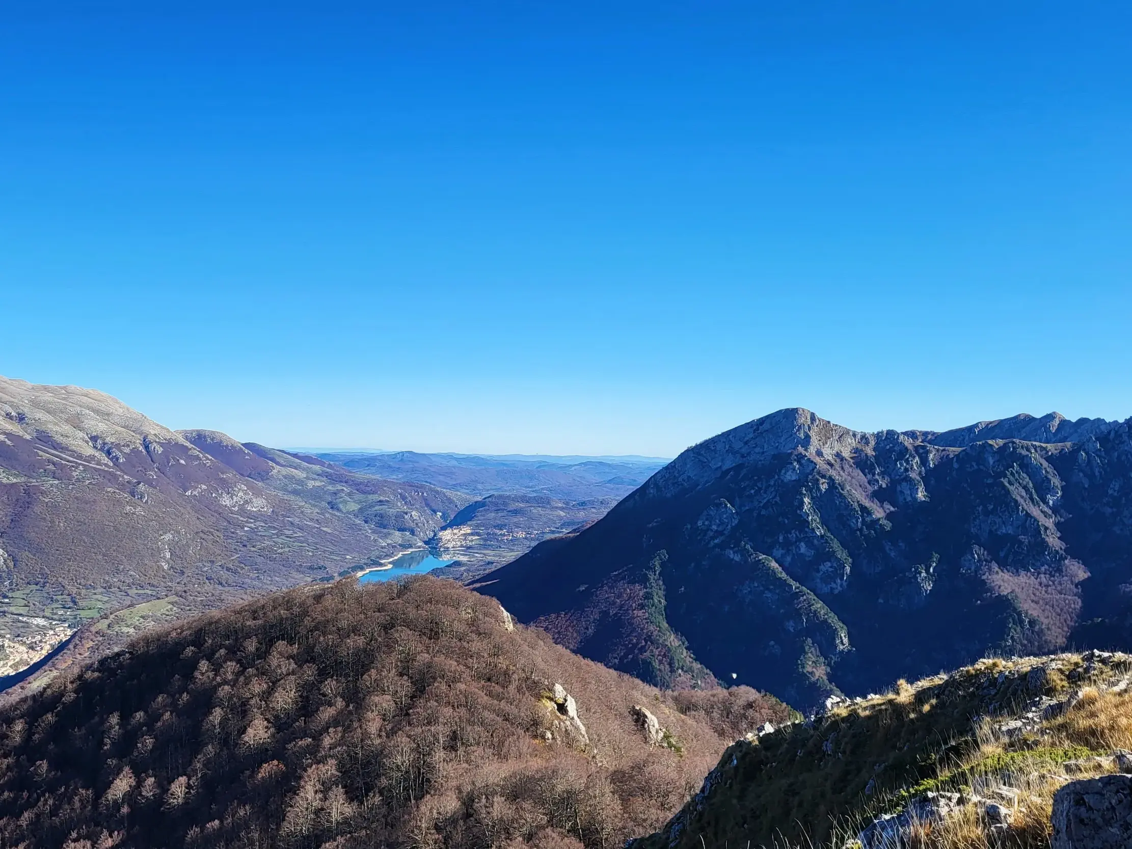 Sonniger Panoramablick von einem Berg auf den türkisblauen Barrea-See im Nationalpark der Abruzzen, Latium und Molise.