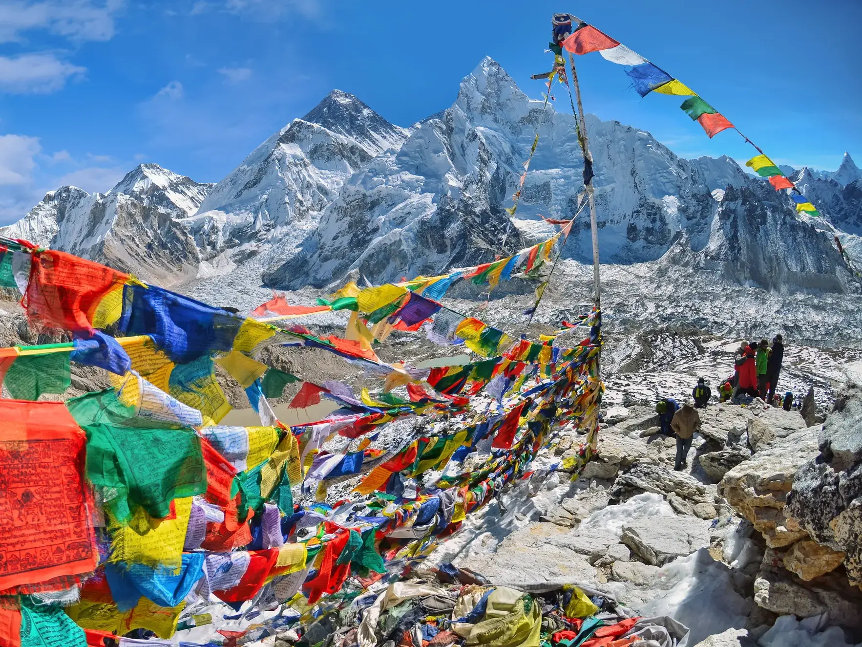 Bunte Gebetsfahnen wehen im Wind am Kala Pattar mit Panoramablick auf den schneebedeckten Gipfel des Mount Everest in Nepal.