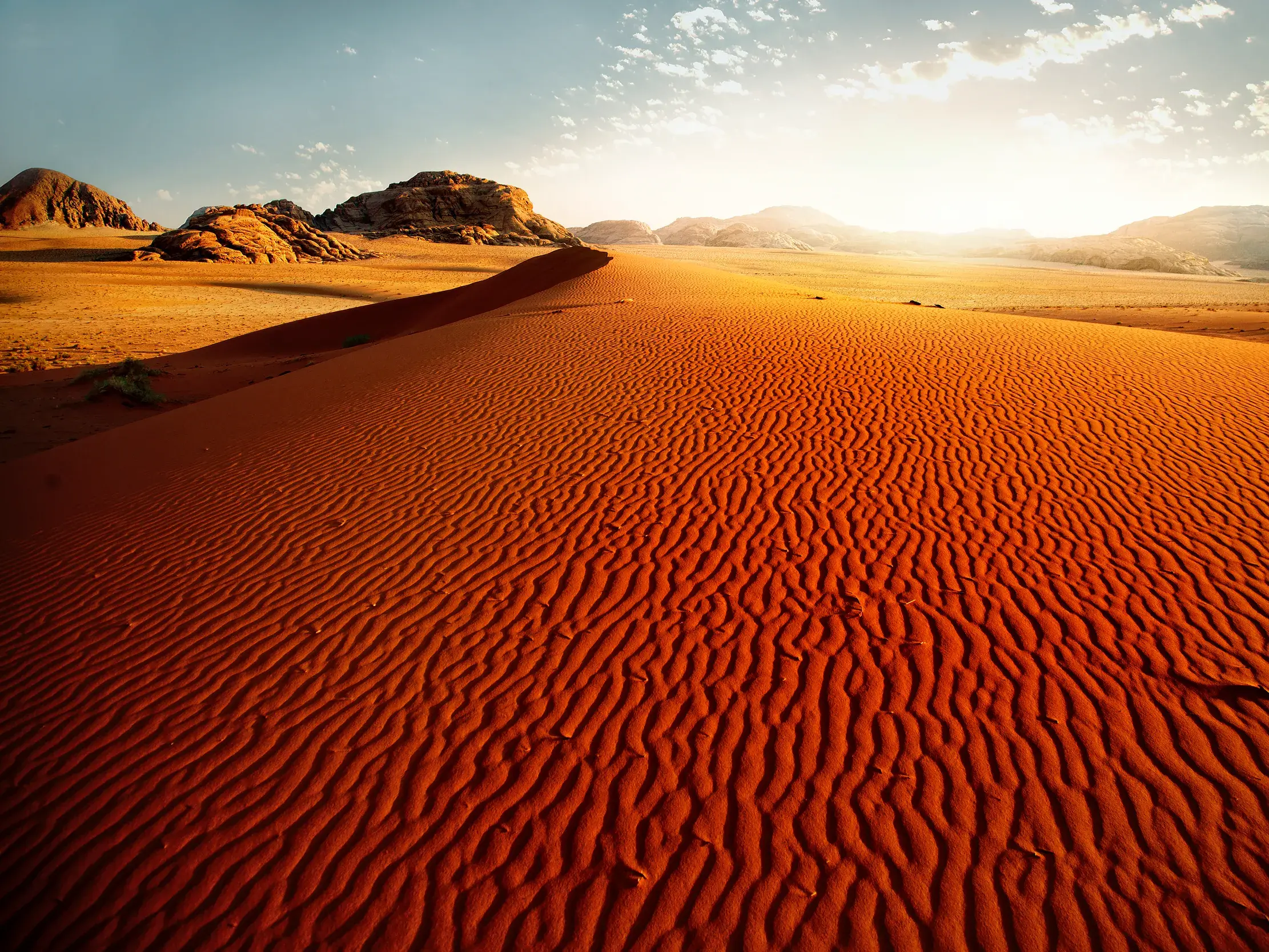 Geriffelte, rote Sanddünen in der Wüste Wadi Ram bei Sonnenuntergang während einer Studiosus Studienreise in Jordanien.