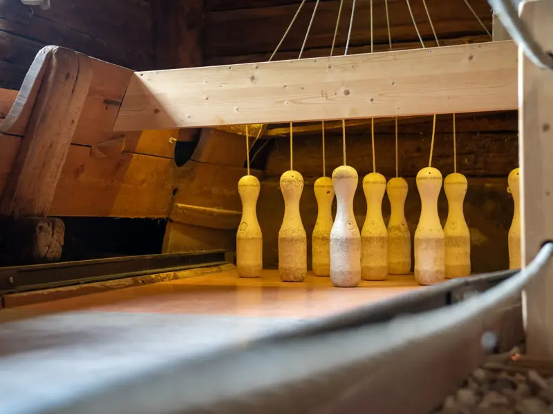 Rustikale, hölzerne Kegelbahn mit aufgestellten Kegeln im historischen Wurzerhof im Villgratental, Osttirol.