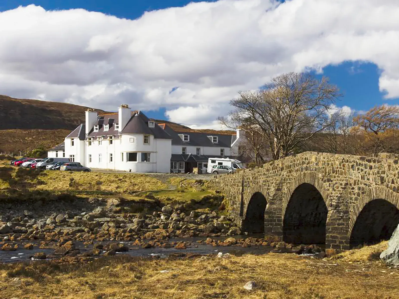 Das auf dem Lande gelegene Hotel Sligachan auf Skye in Schottland. Hier übernachten Sie 3 Nächte in einem altehrwürdigen Gebäude, umgeben von kargen Hügeln, direkt an der fotogenen Sligachan-Brücke.