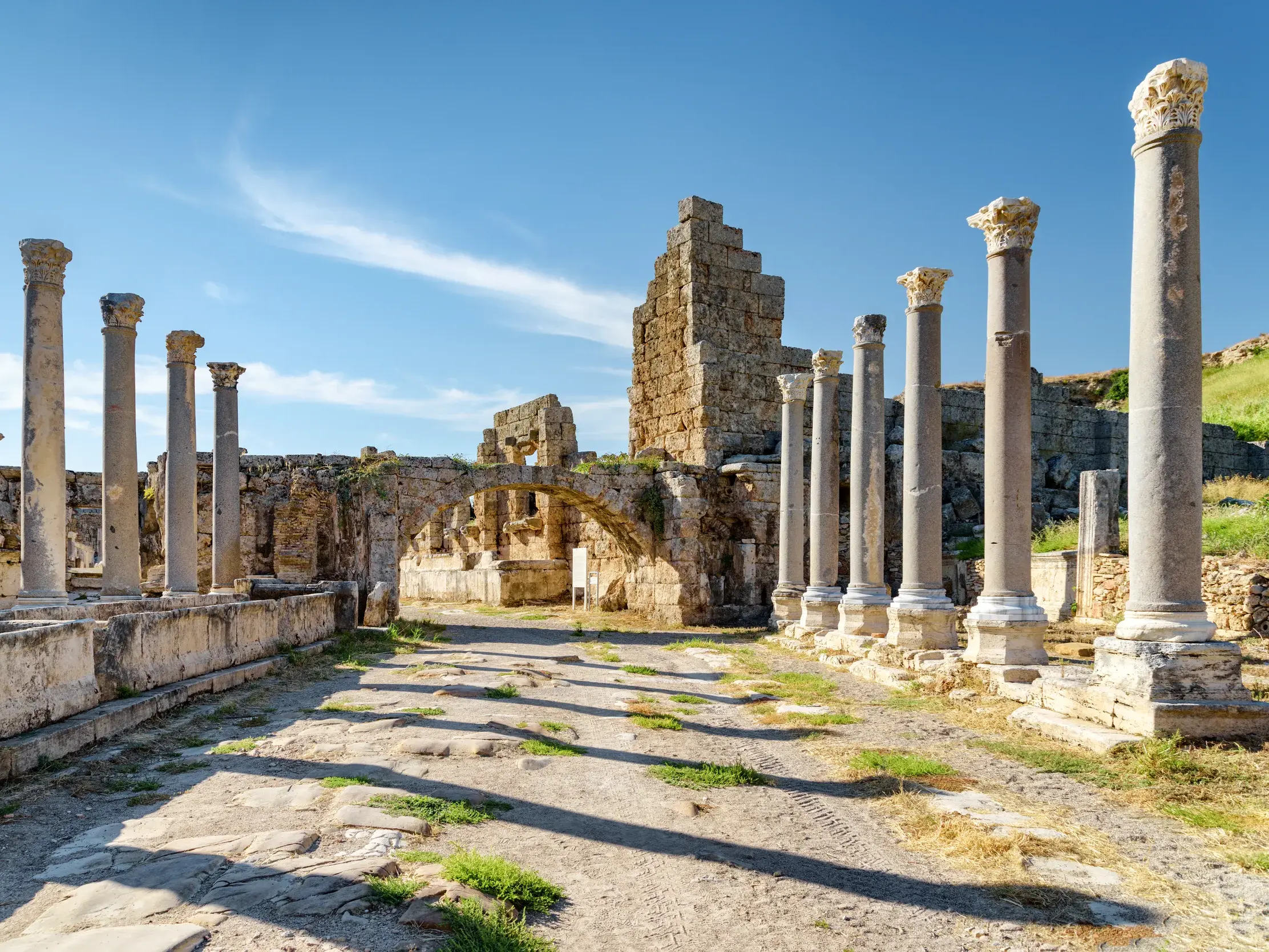Der arkadengesäumte Boulevard in der antiken Stätte Perge mit den Resten des hellenistischen Stadttors bei Antalya.