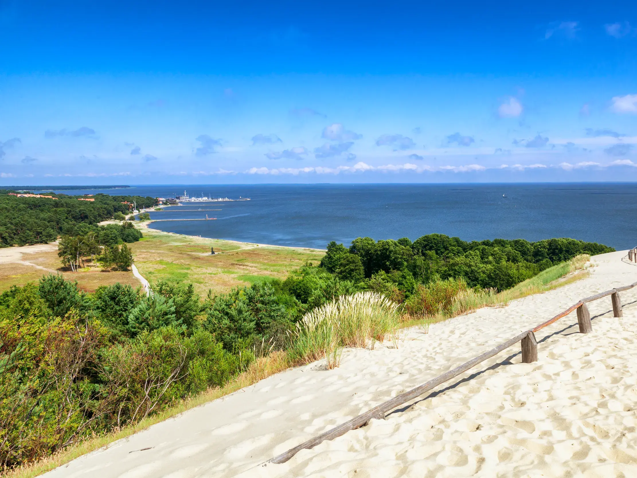 Sonniger Panoramablick vom Parniddener Berg auf der Kurischen Nehrung über die weite Dünenlandschaft und das Kurische Haff.