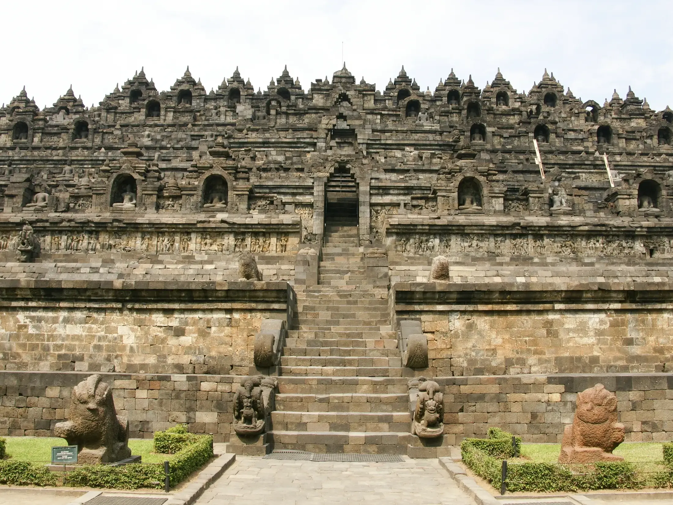 Frontansicht der monumentalen UNESCO-Tempelanlage Borobudur auf Java, die über eine zentrale Steintreppe zugänglich ist.