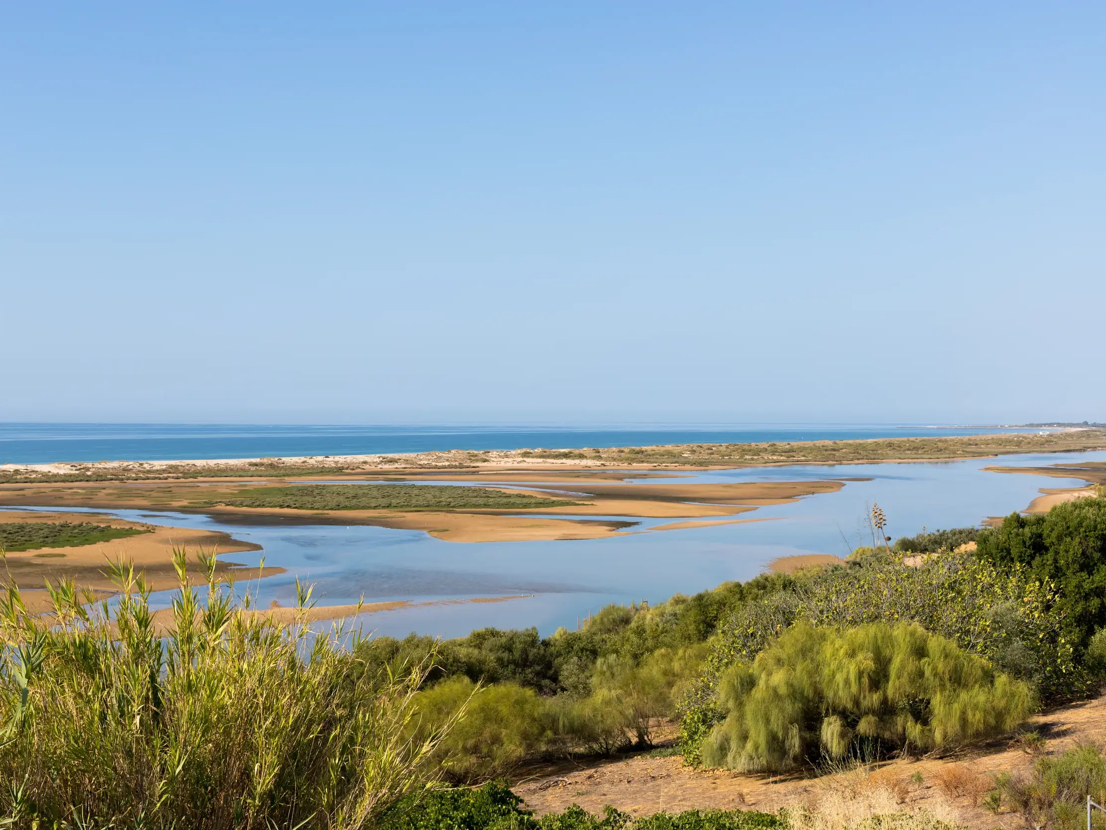 Blick von einem Wanderweg über die Sandbänke und Wasserstraßen des Naturparks Ria Formosa an der Ostalgarve.