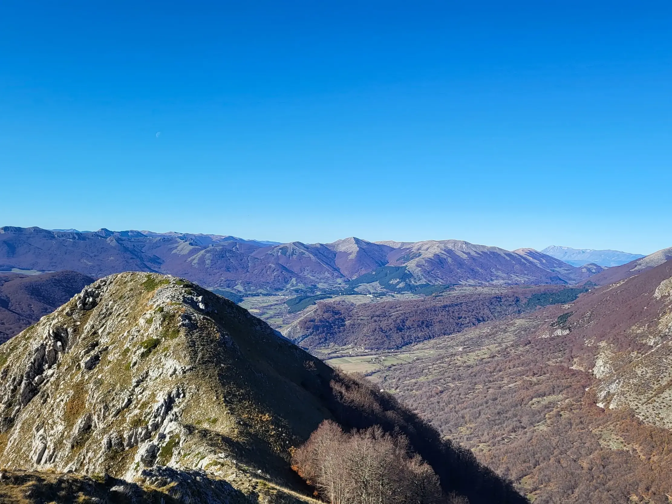 Panoramablick bei einer Wanderung im Nationalpark der Abruzzen über karge Bergrücken und weite Täler im Zentralapennin.