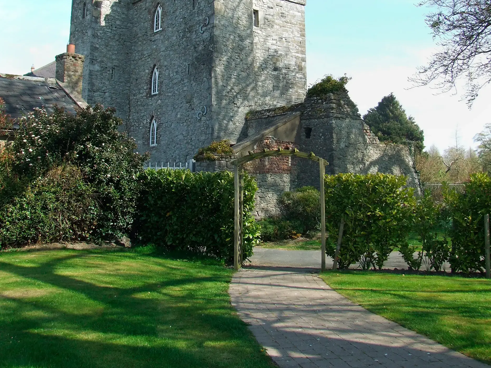 Gepflegter Gartenweg zum historischen Viersternehotel Barberstown Castle mit alten Burgmauern bei Dublin in Irland.