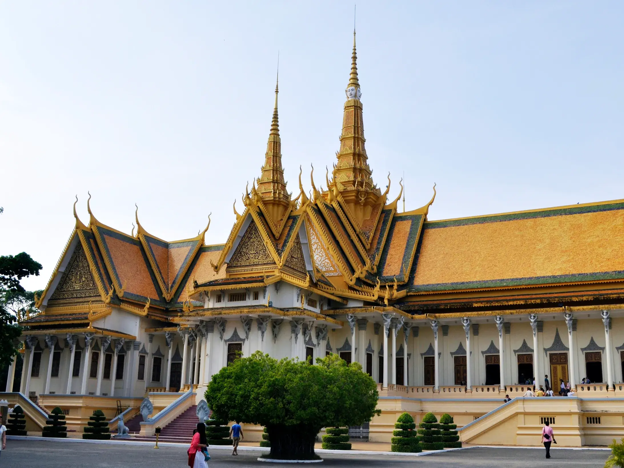 Besucher vor dem prächtigen Königspalast in Phnom Penh mit seinen goldverzierten Khmer-Dächern und Türmen.