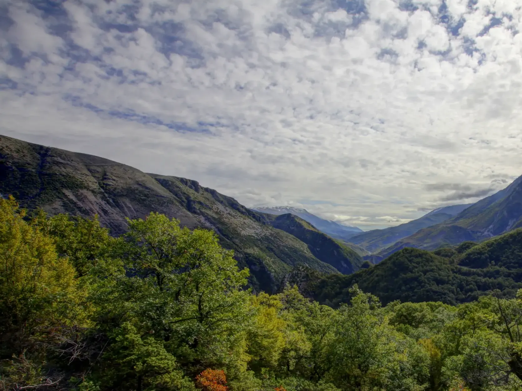 Beim Trekking in Südalbanien eröffnet sich der weite Blick über die grünen Hänge und Berge des Zagoria-Tals.