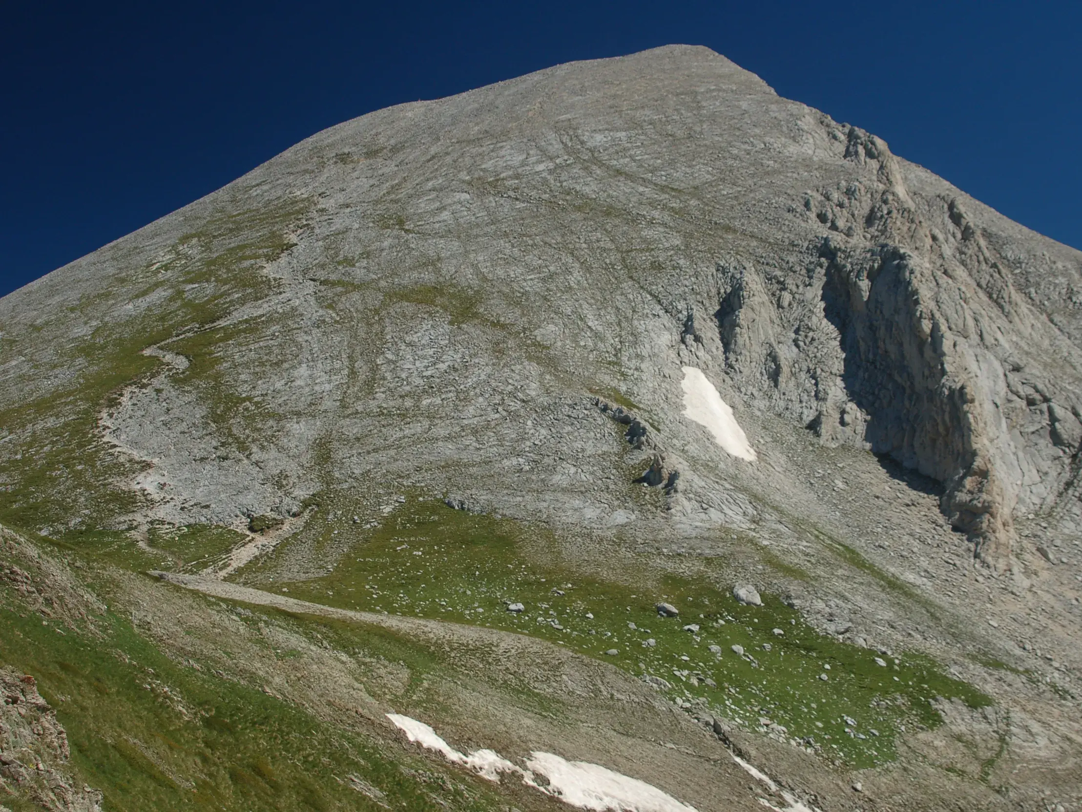 Steiler Wanderpfad führt auf den felsigen Gipfel des Wichren im Pirin-Gebirge in Bulgarien an einem sonnigen Tag.