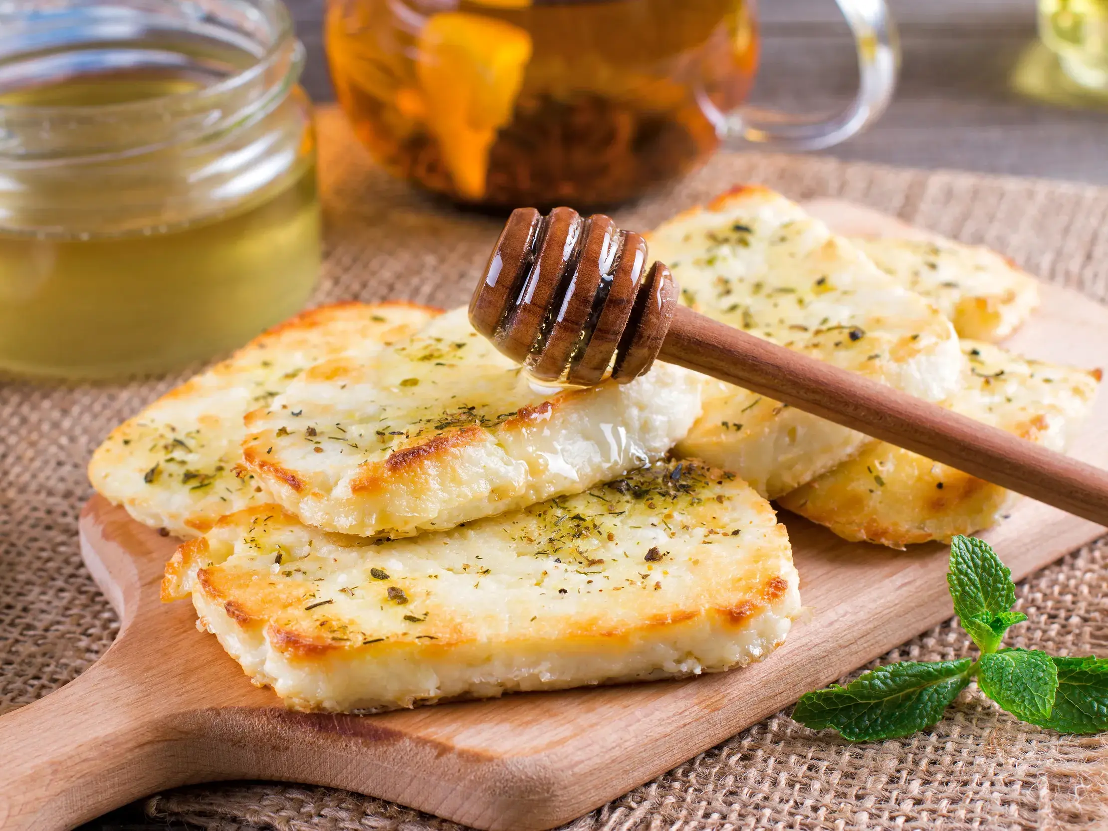 Gebratener Halloumi-Käse mit Kräutern und Honig auf einem Holzbrett, ein kulinarisches Highlight der Zypern-Reise.