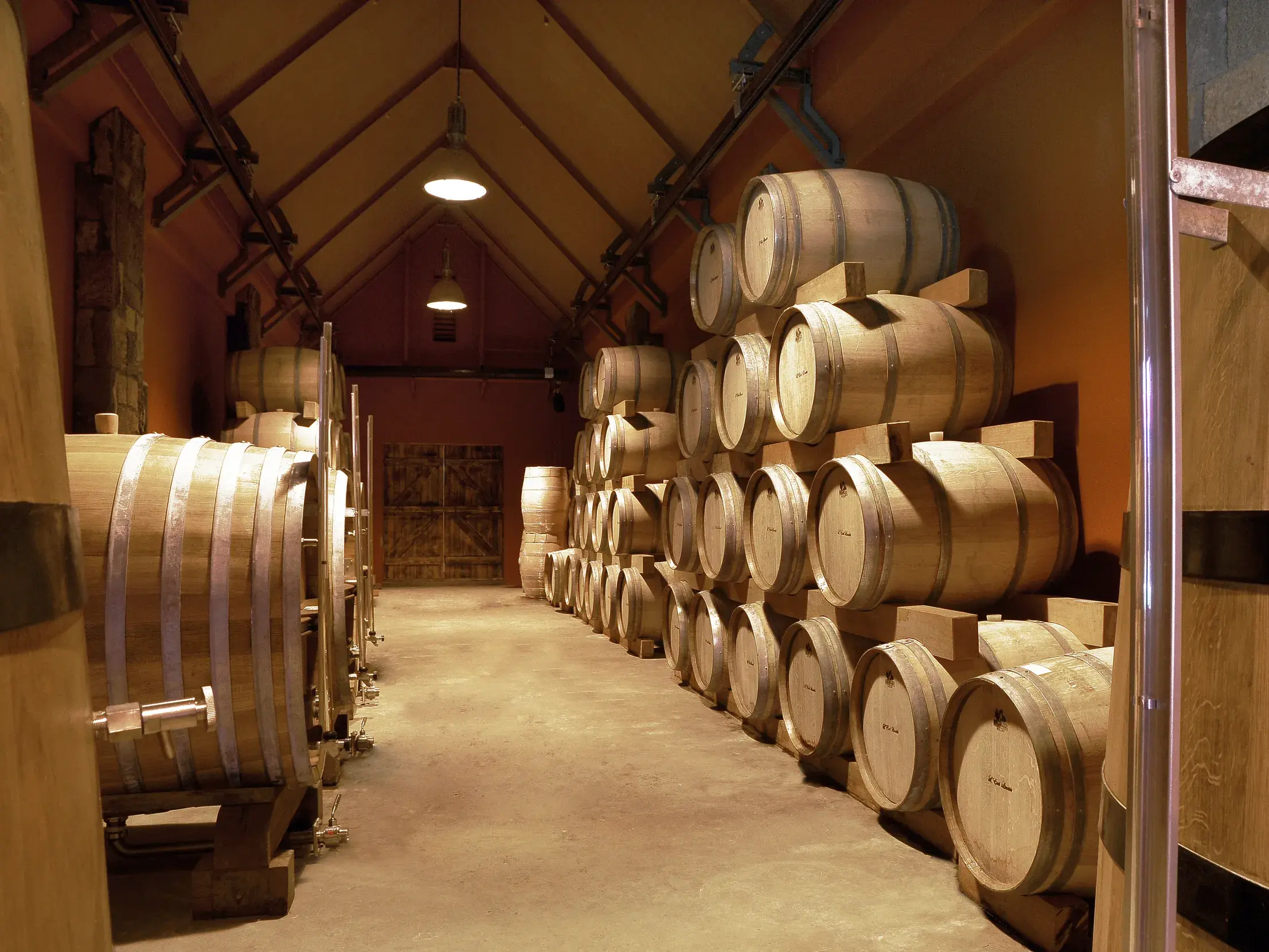 Zahlreiche Holzfässer lagern in einem stimmungsvollen Keller der traditionsreichen Rum-Destillerie in Chamarel auf Mauritius.