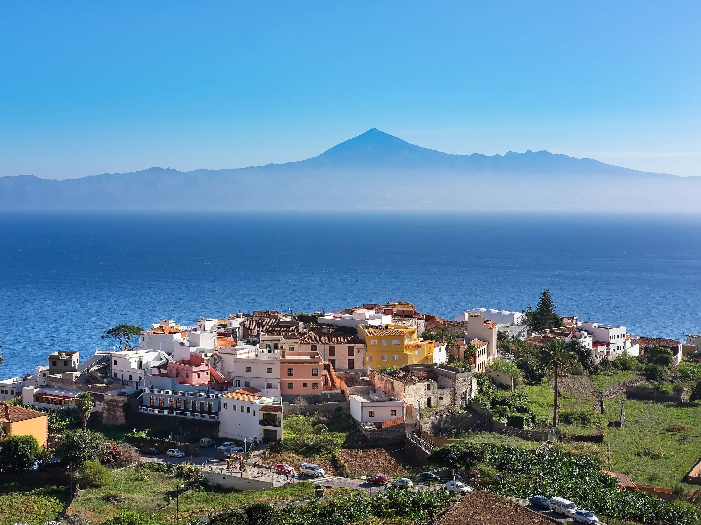 Das malerische Küstendorf Agulo auf La Gomera vor der Kulisse des Atlantiks und des Vulkans Teide auf Teneriffa.