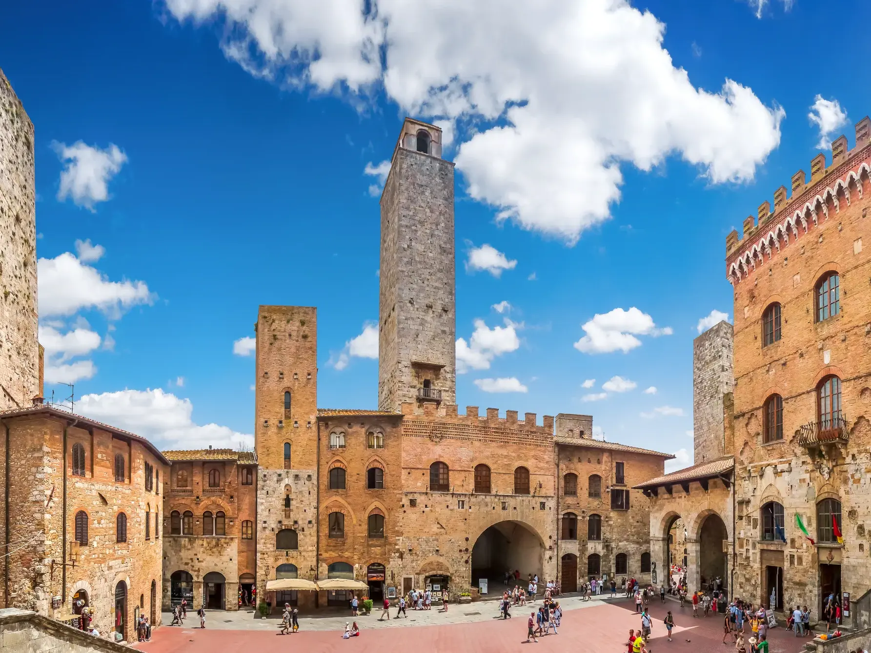 Sonnige Panoramaansicht des belebten Platzes mit den mittelalterlichen Türmen von San Gimignano, dem Manhattan der Toskana.