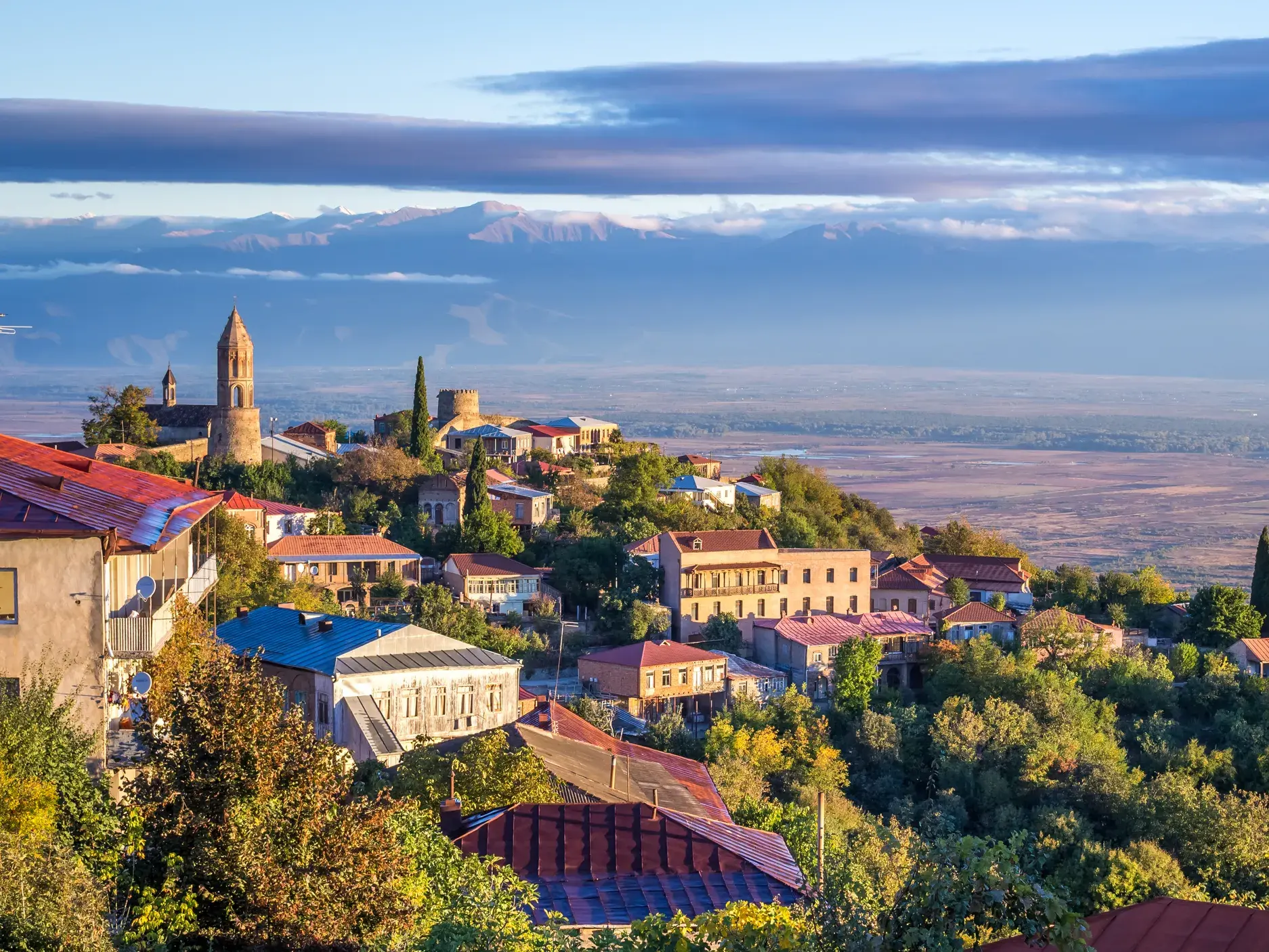 Panoramablick auf die Hügelstadt Sighnaghi in Georgiens Weinregion Kachetien mit dem Großen Kaukasus im Hintergrund.