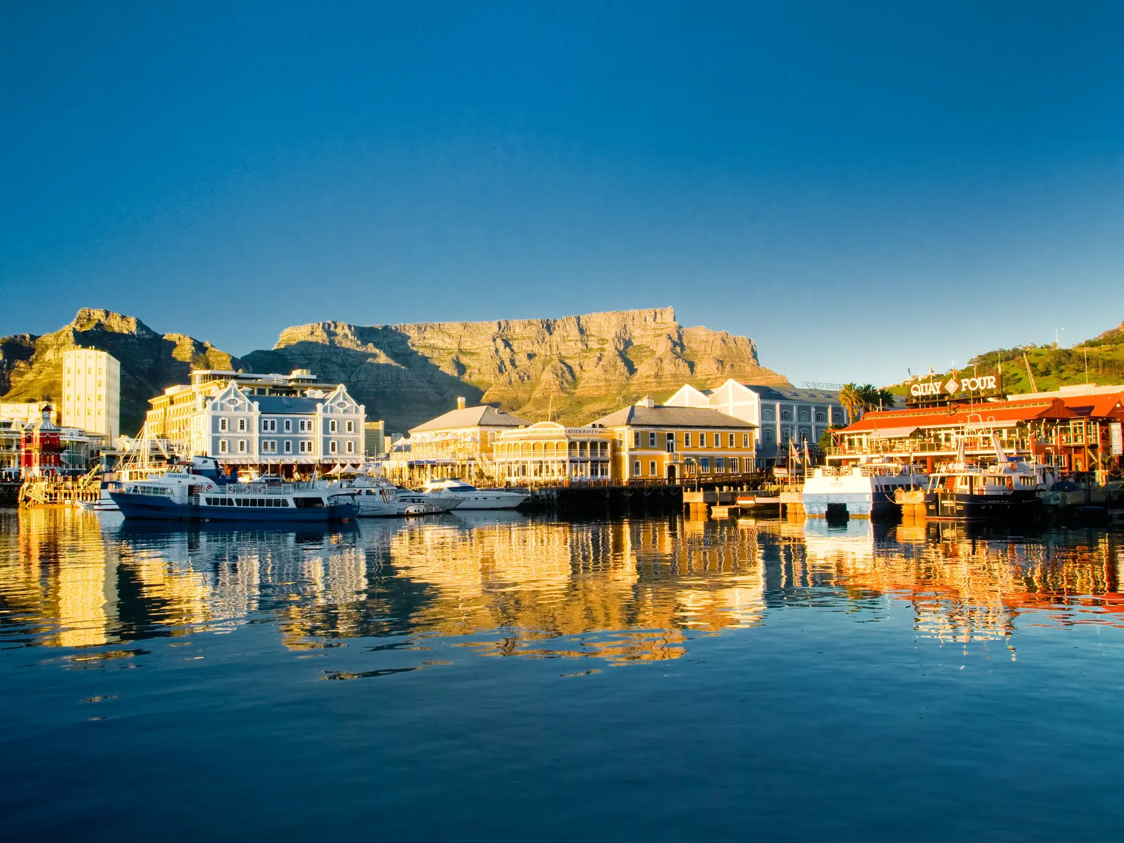 Die V&A Waterfront in Kapstadt im warmen Abendlicht mit dem Tafelberg im Hintergrund, ein Highlight der Studiosus Studienreise.