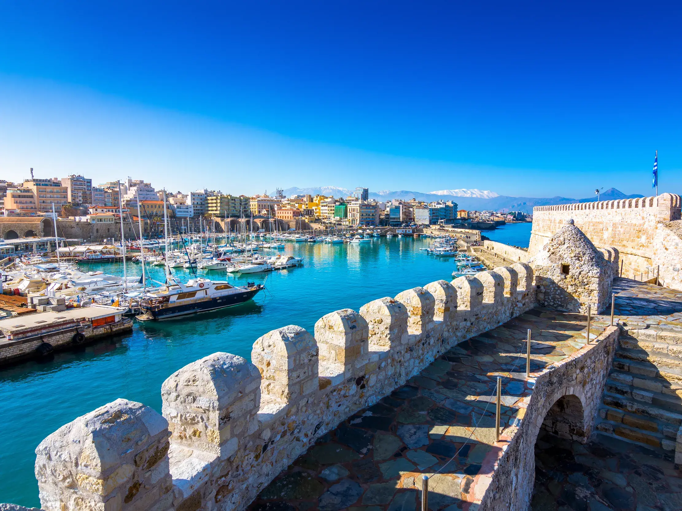 Blick von der historischen Koules-Festung auf den venezianischen Hafen von Heraklion auf Kreta bei strahlend blauem Himmel.