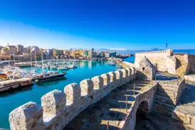 Blick von der historischen Koules-Festung auf den venezianischen Hafen von Heraklion auf Kreta bei strahlend blauem Himmel.