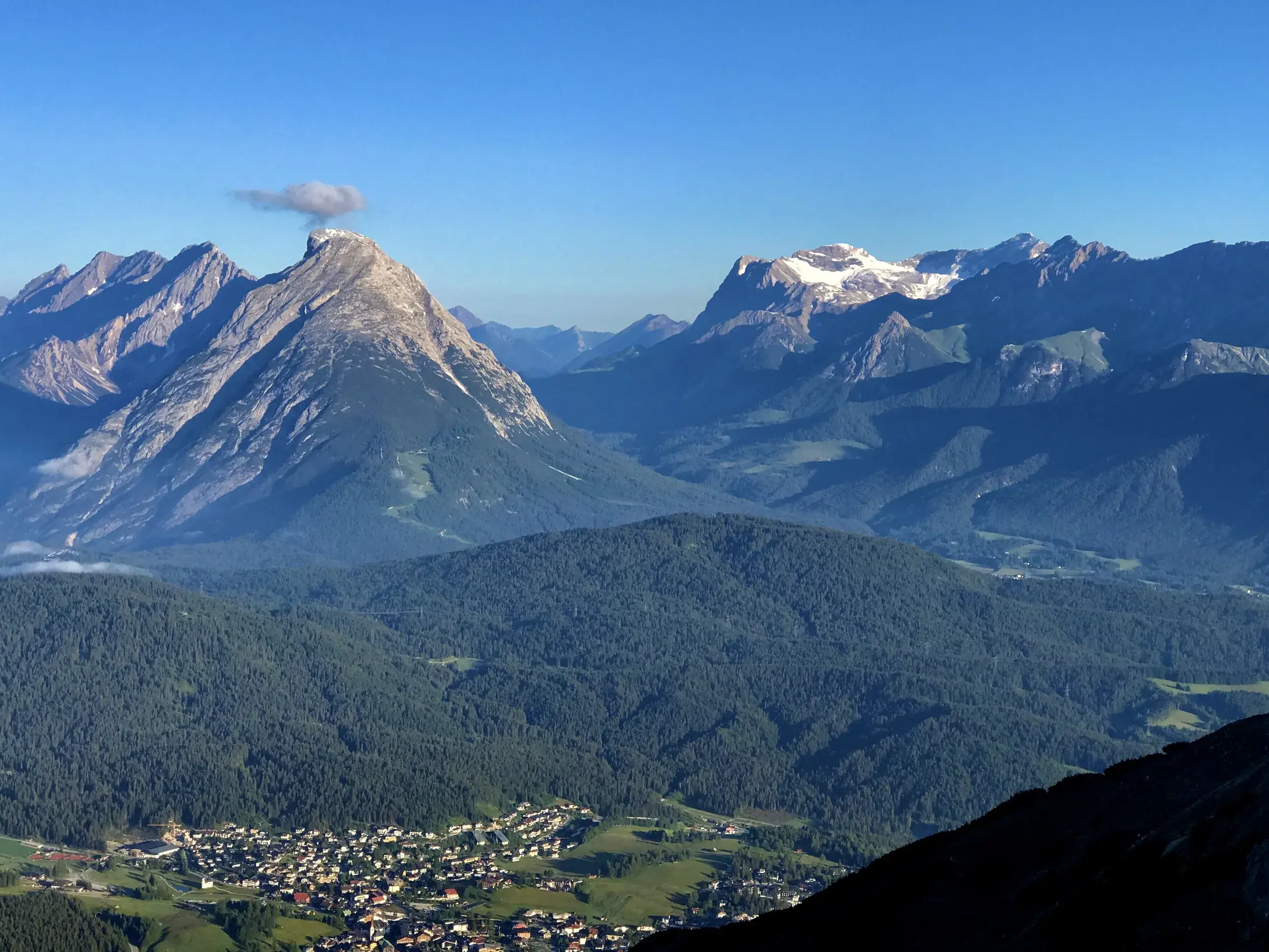 Sonniges Bergpanorama im Karwendelgebirge mit Blick auf markante Gipfel, bewaldete Täler und das Inntal in Tirol.