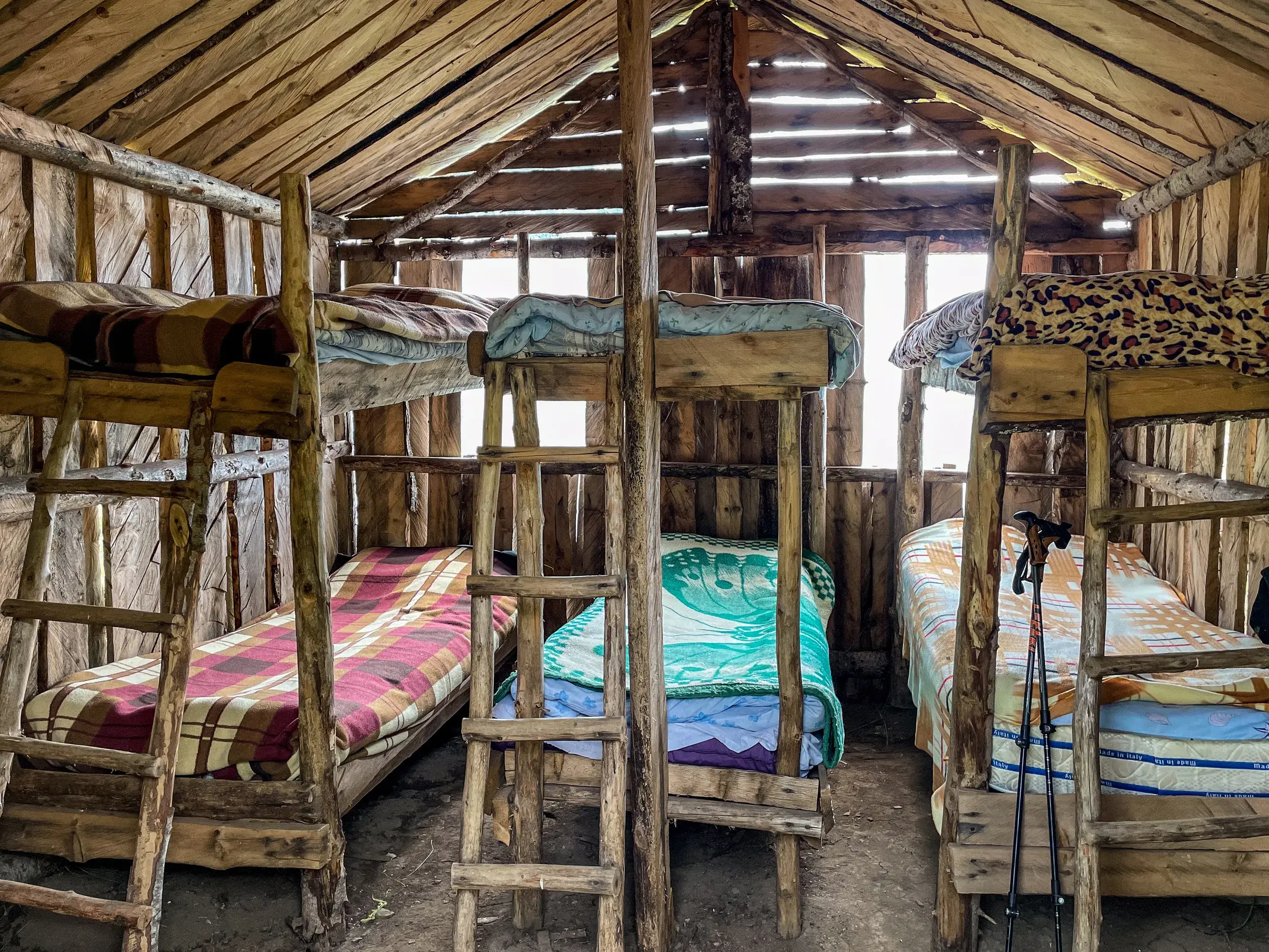 Rustikale Etagenbetten aus Holz in einer einfachen Schäferhütte auf der Grama-Alm während einer Trekkingreise in Albanien.