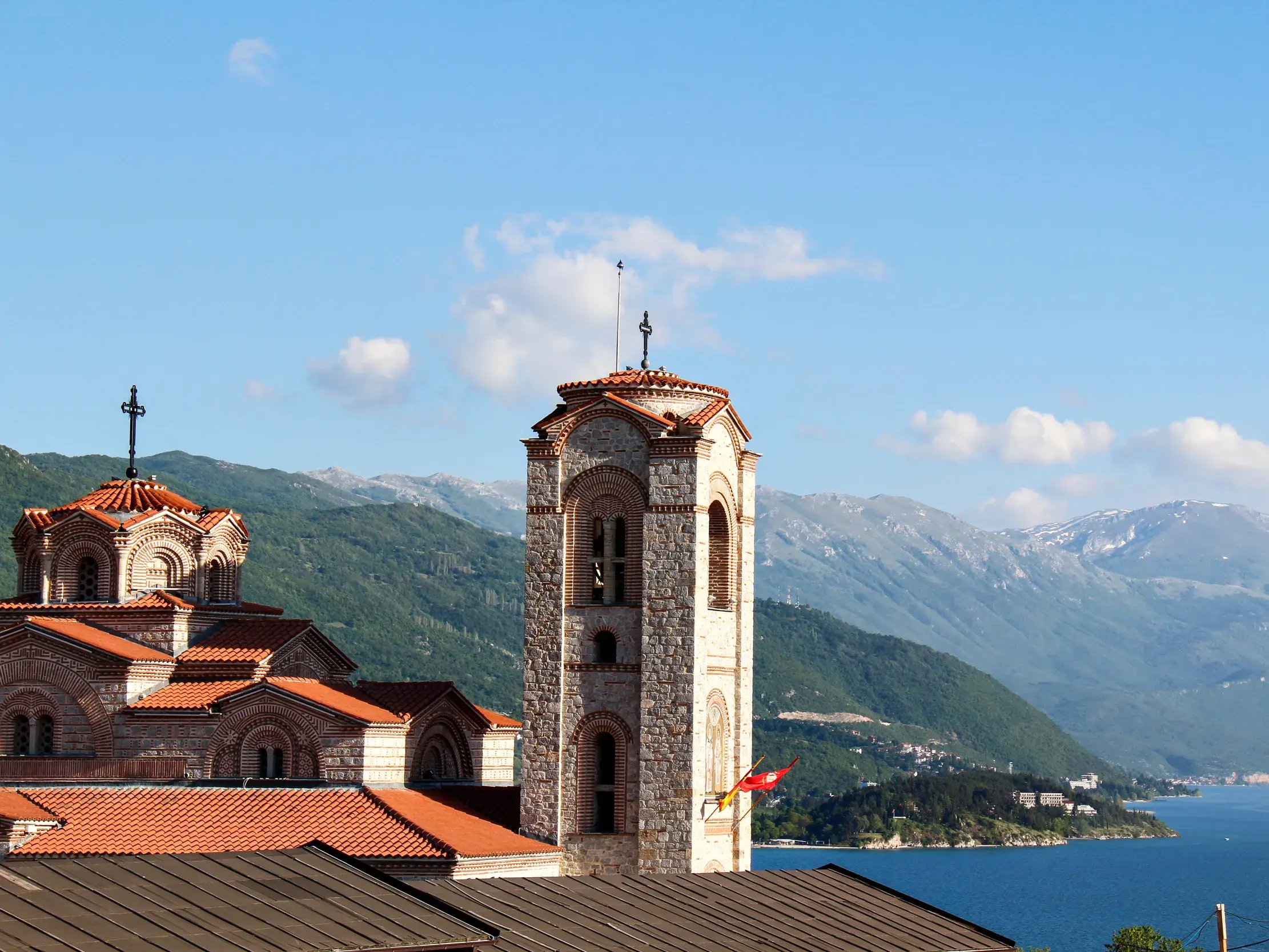 Steinerner Kirchturm einer orthodoxen Kirche am Ohridsee, im Hintergrund die Berge des Galicica-Nationalparks in Nordmazedonien.