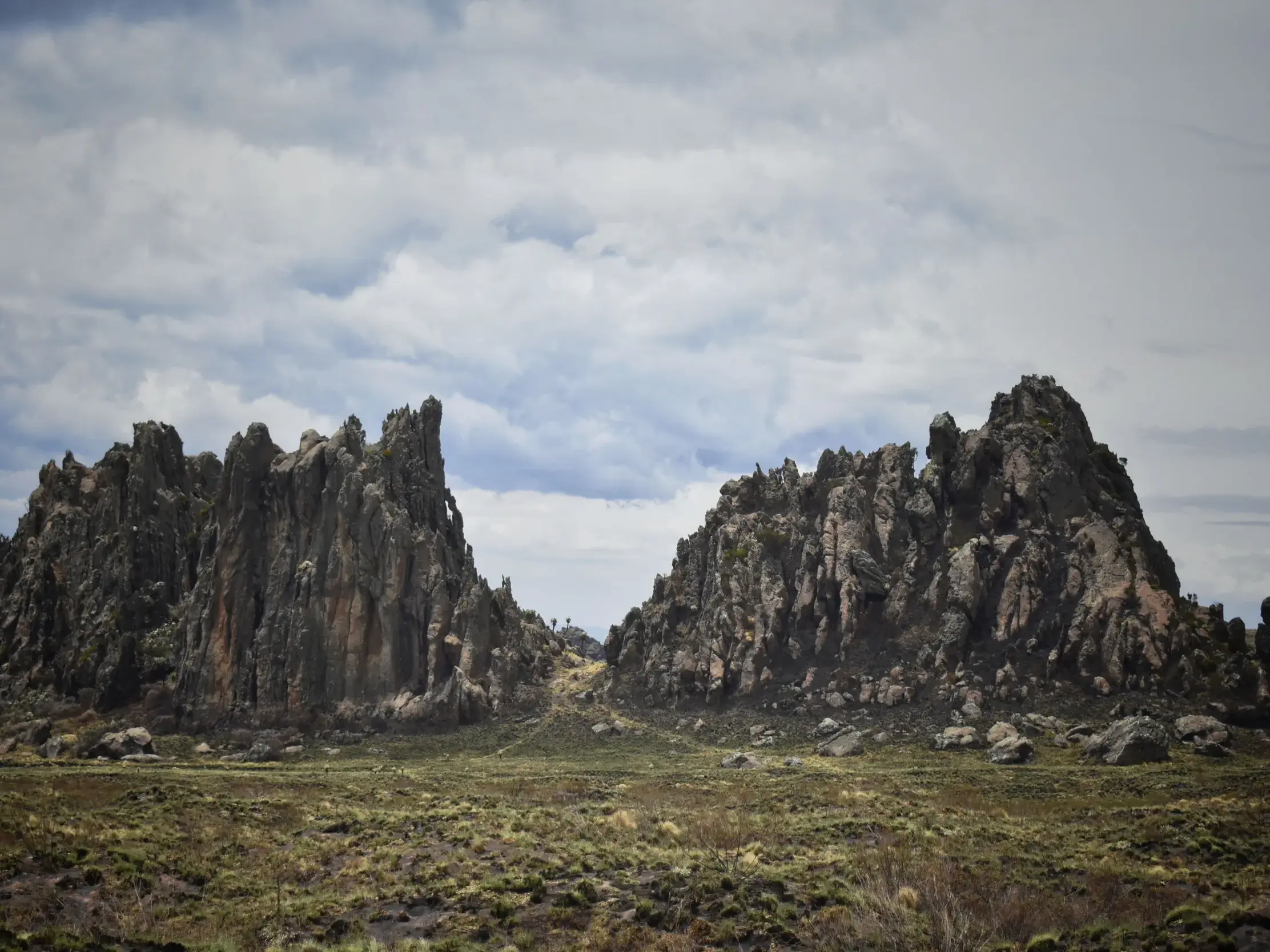 Markante Felsformation der Drachenzähne im Aberdare-Nationalpark, durchquert von Wanderern auf ihrer Trekking-Tour in Kenia.