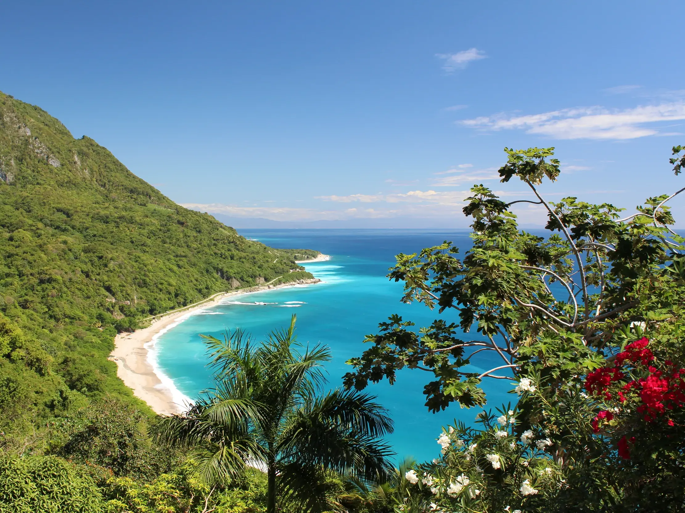 Panoramablick auf die Küstenstraße im Nationalpark Jaragua mit Traumstrand, türkisfarbenem Meer und üppiger Vegetation.