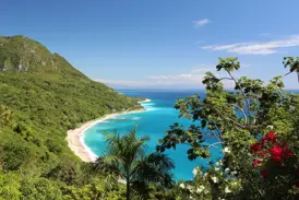 Panoramablick auf die Küstenstraße im Nationalpark Jaragua mit Traumstrand, türkisfarbenem Meer und üppiger Vegetation.